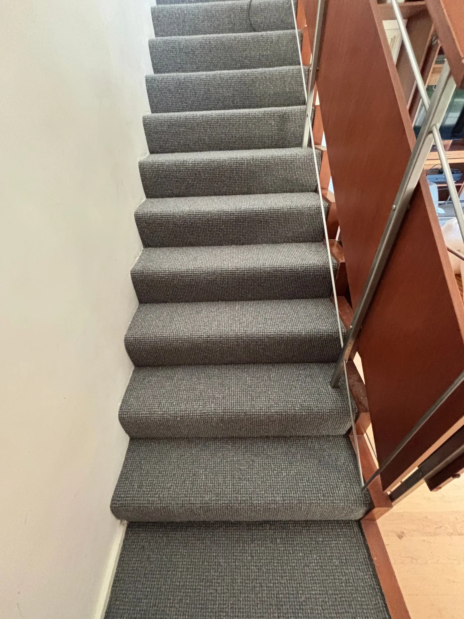 Grey wool loop carpet wrapped over each tread and riser