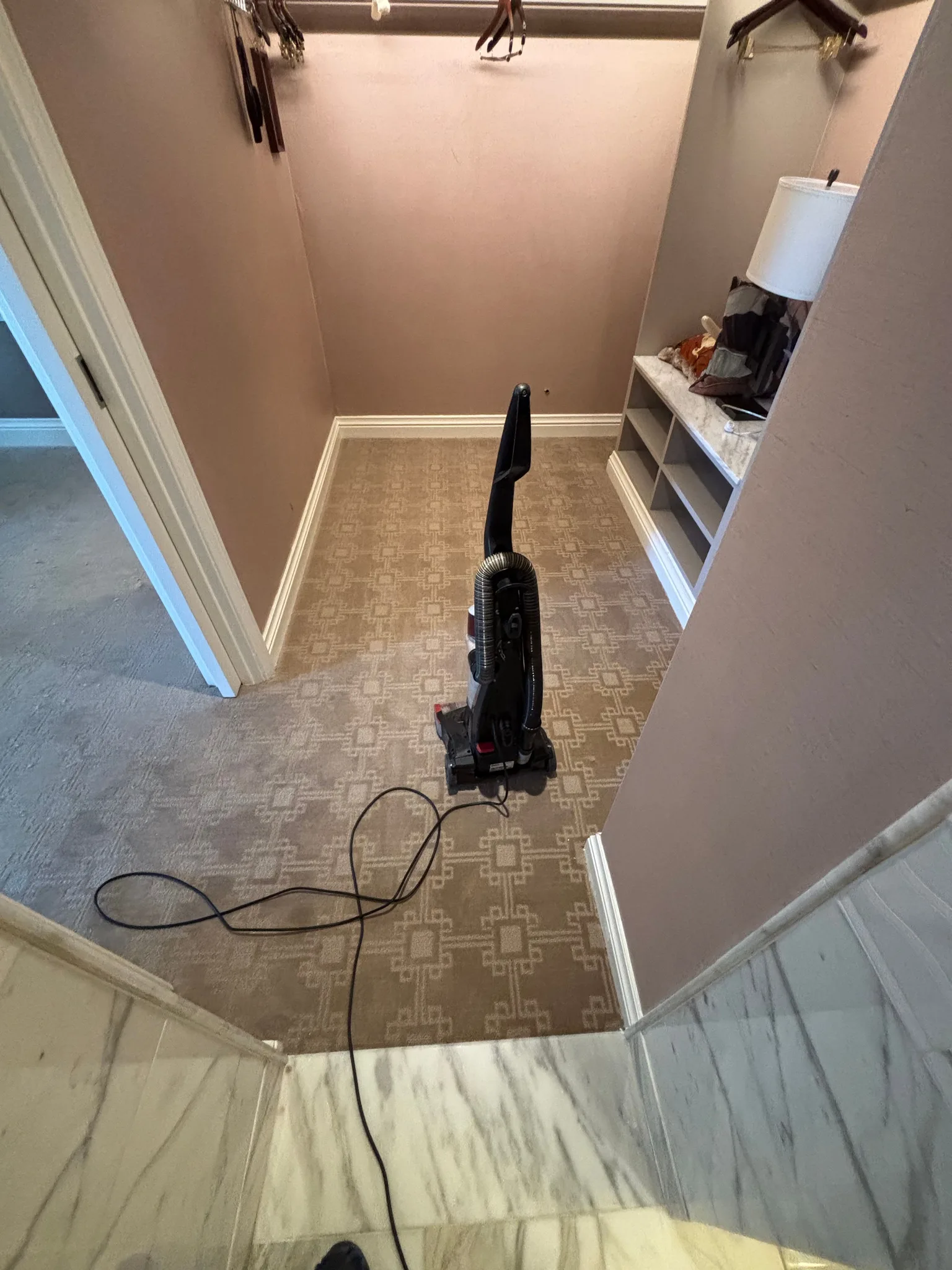 Taupe geometric cut-and-loop carpet fitted into a dressing alcove