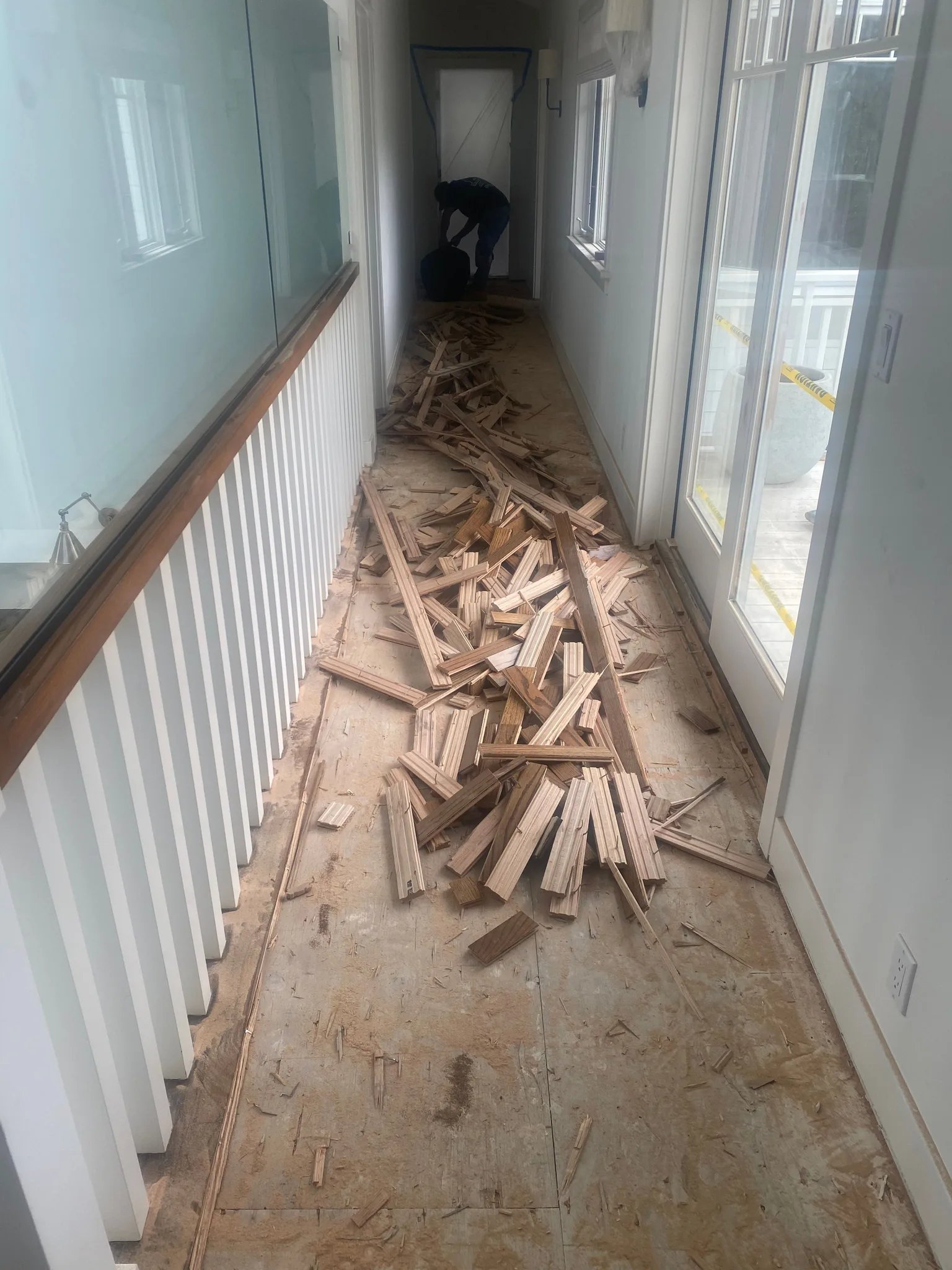 Nailed-down strip flooring pulled up, plywood subfloor exposed