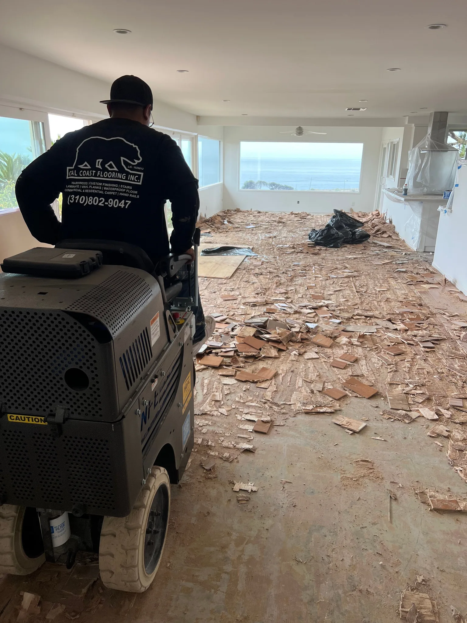Ride-on scraper lifting glued-down wood flooring