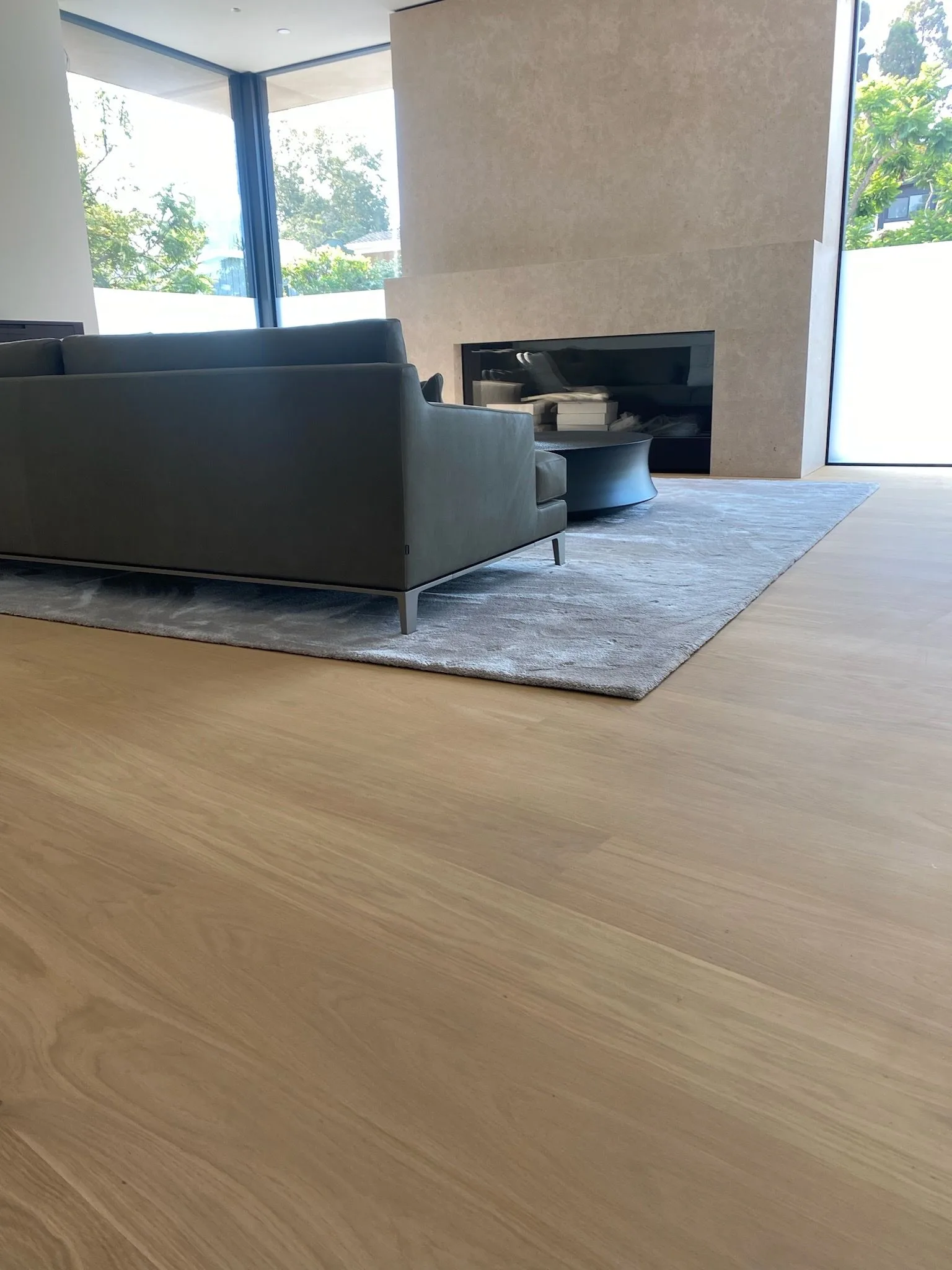 Wide-plank European oak across the living room to a stone fireplace in Santa Monica