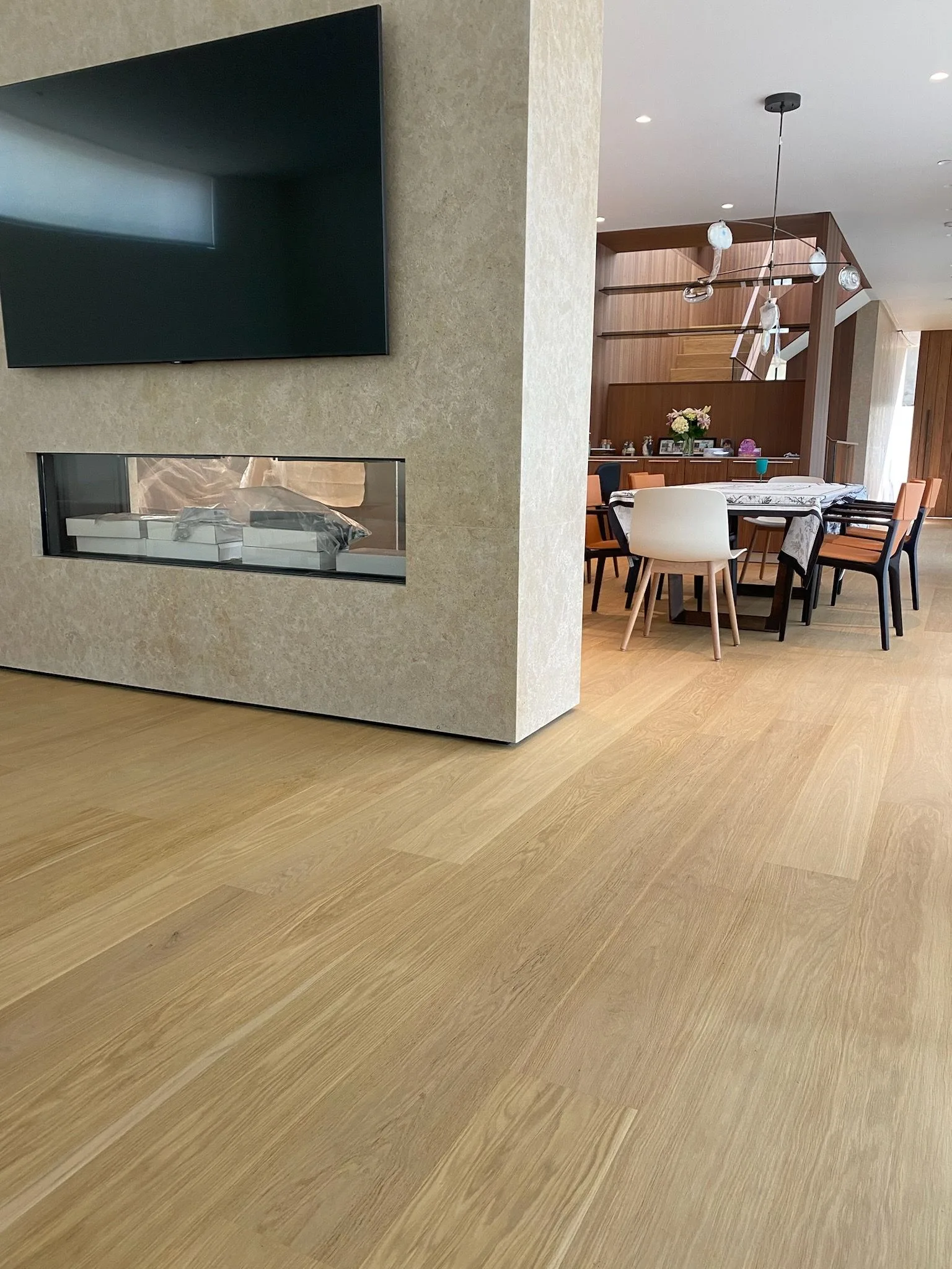 Tinted European oak past a two-sided fireplace into the dining room in Santa Monica