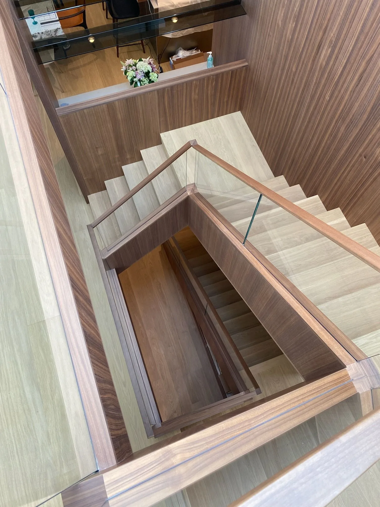 Looking down the oak stairwell, walnut handrails and glass in Santa Monica
