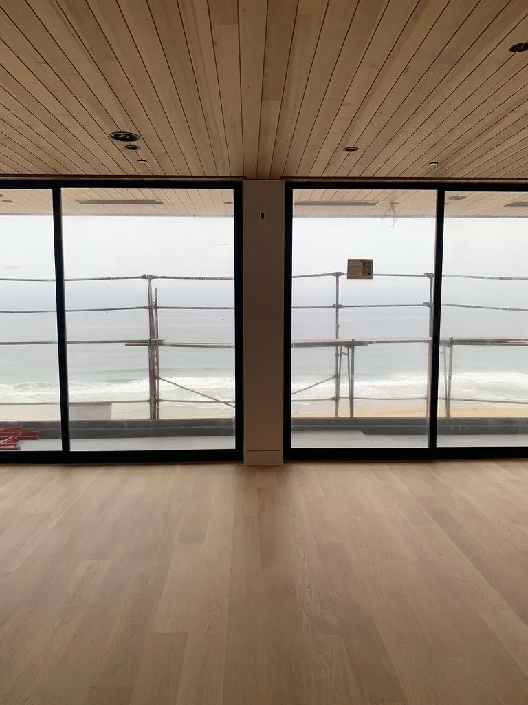 Wide-plank oak running to floor-to-ceiling glass and the ocean beyond in Redondo Beach
