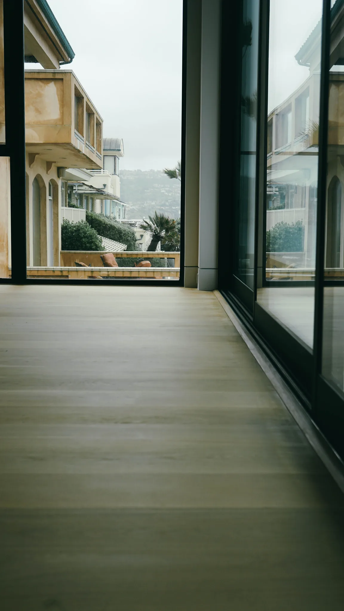White oak planks meeting the threshold of a sliding door to the balcony in Redondo Beach