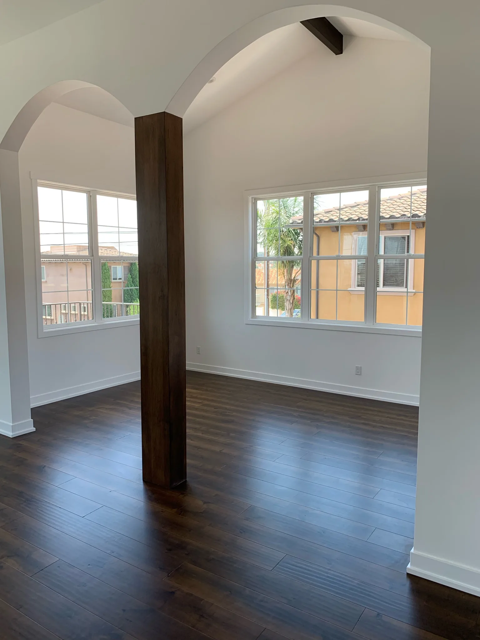 Dark maple planks under an arched opening and a stained post in Redondo Beach