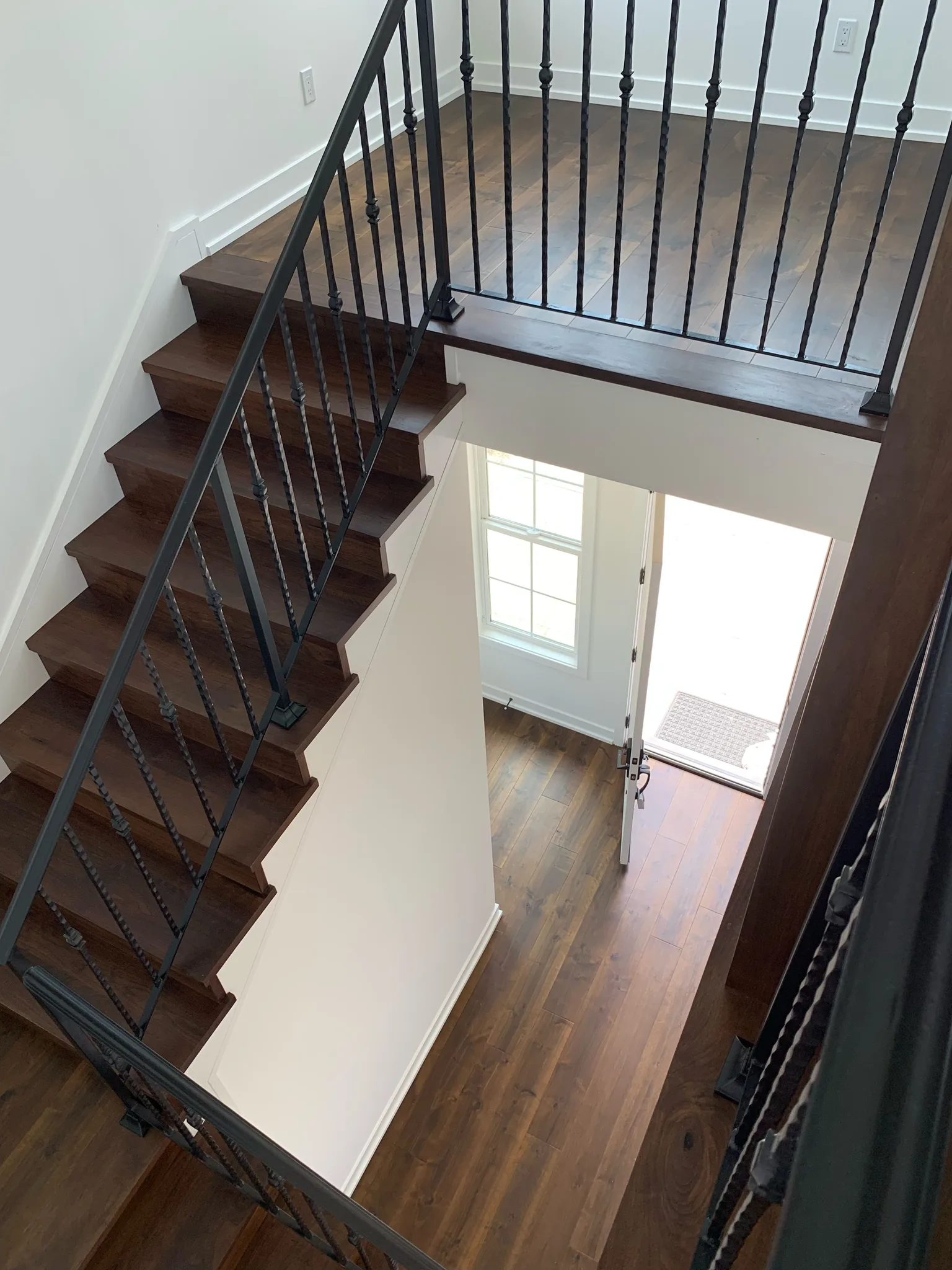 Maple stair from above, stained treads meeting the dark plank floor at the entry in Redondo Beach