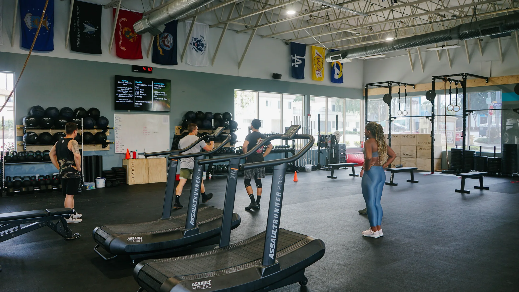 All-black sport rubber floor across the gym, curved treadmills and the rig beyond in Redondo Beach