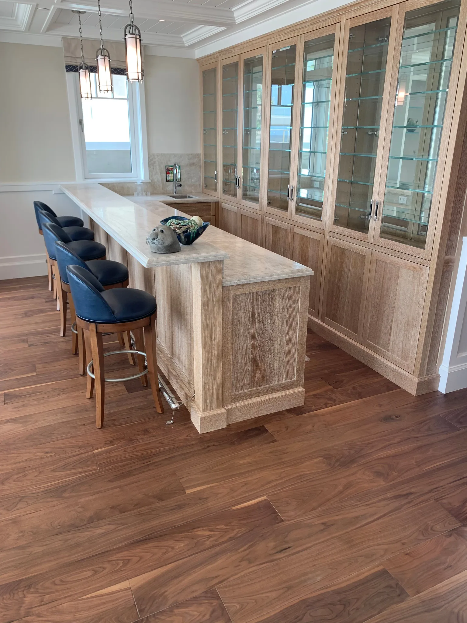Dark walnut plank flooring under pale oak bar cabinetry
