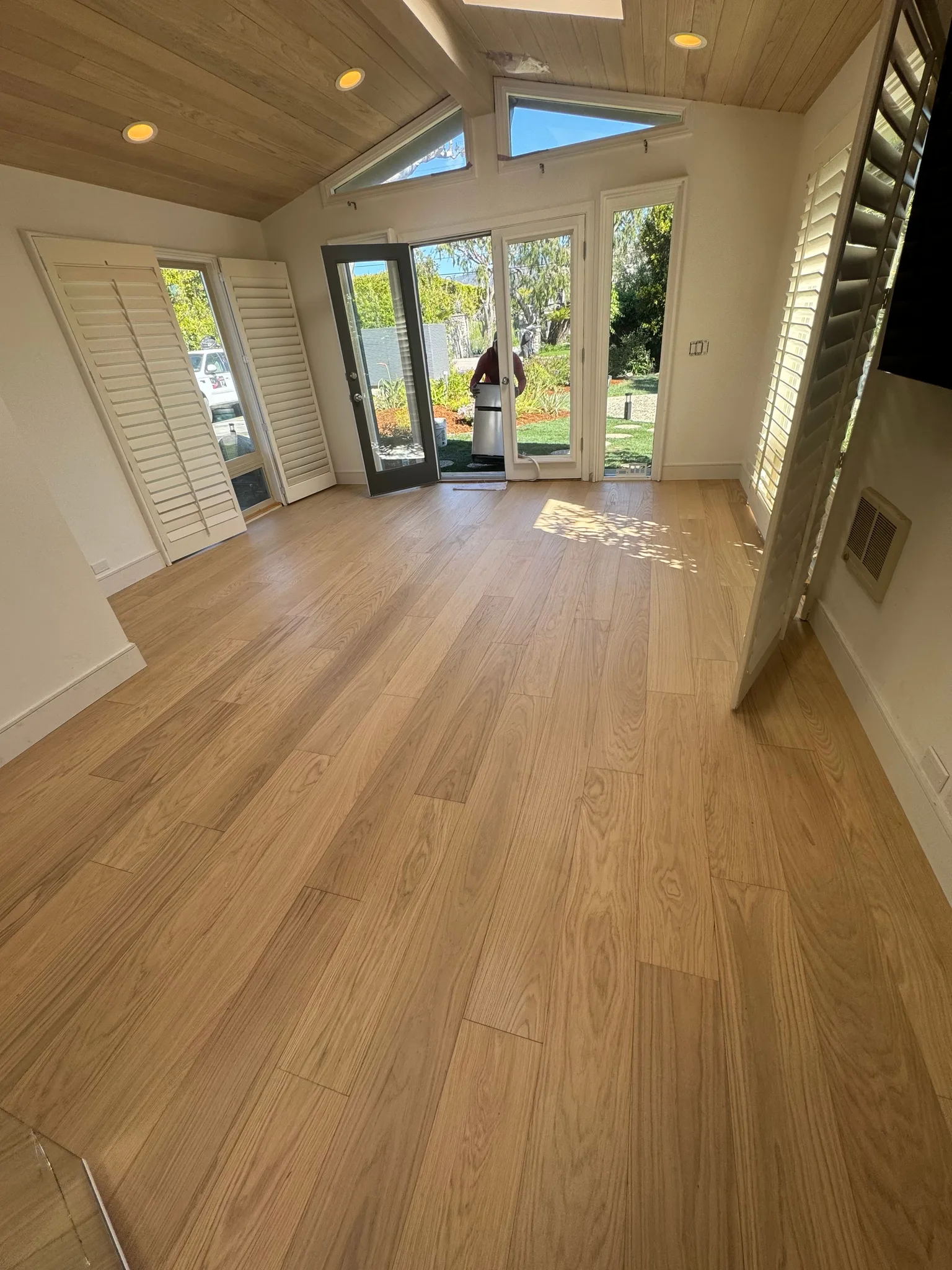 Wide-plank oak in a satin finish under a wood-plank ceiling