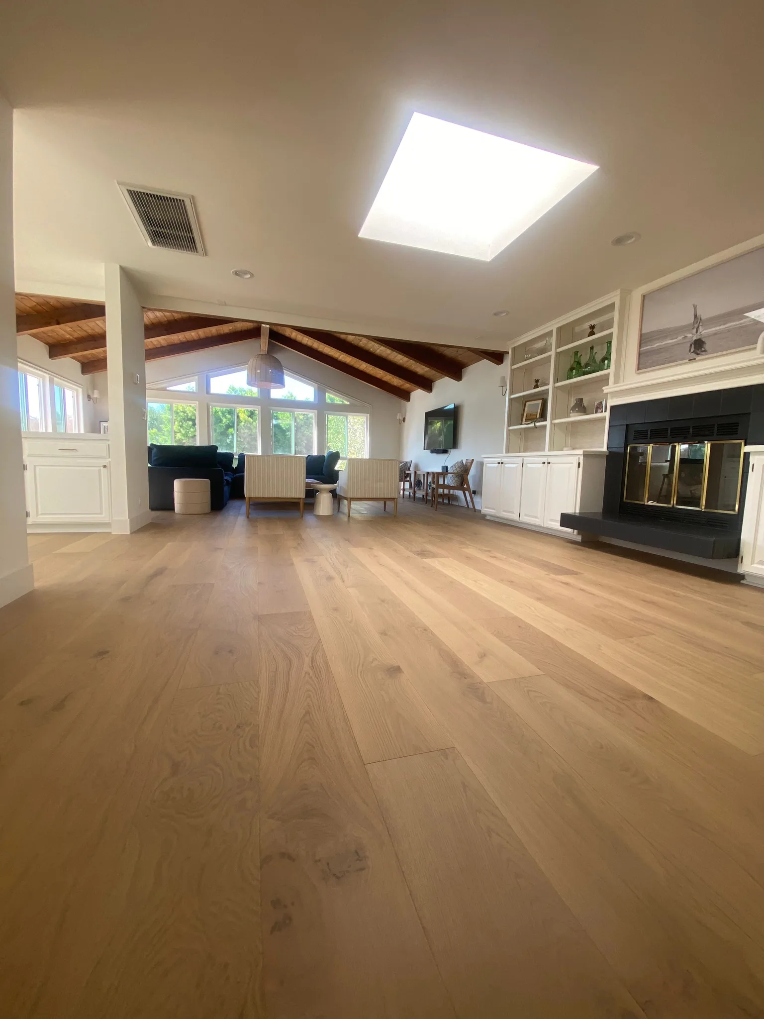 Wide-plank white oak in a natural finish under a beamed ceiling