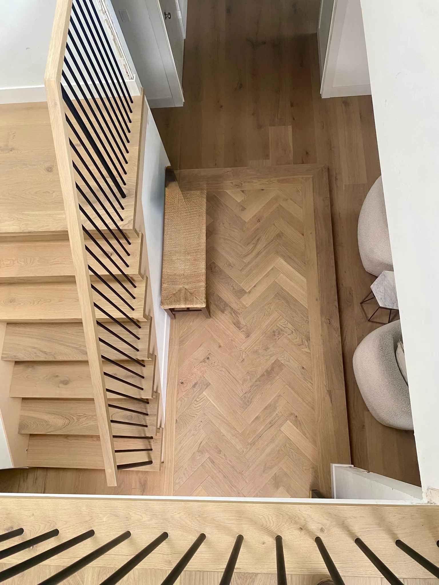 White oak herringbone with a plank border and matching stair treads