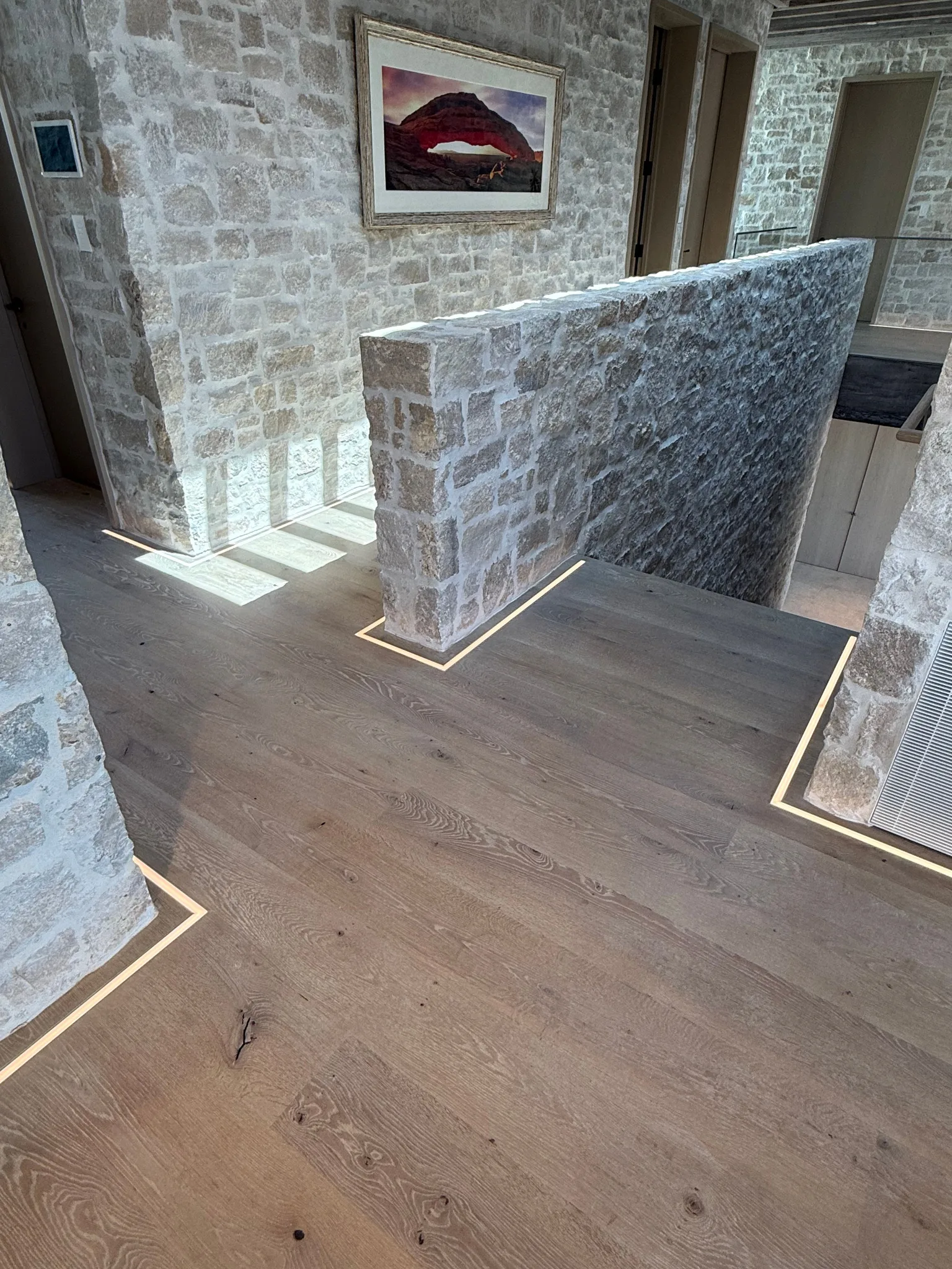 Custom stained white oak under stone walls with LED light strip features