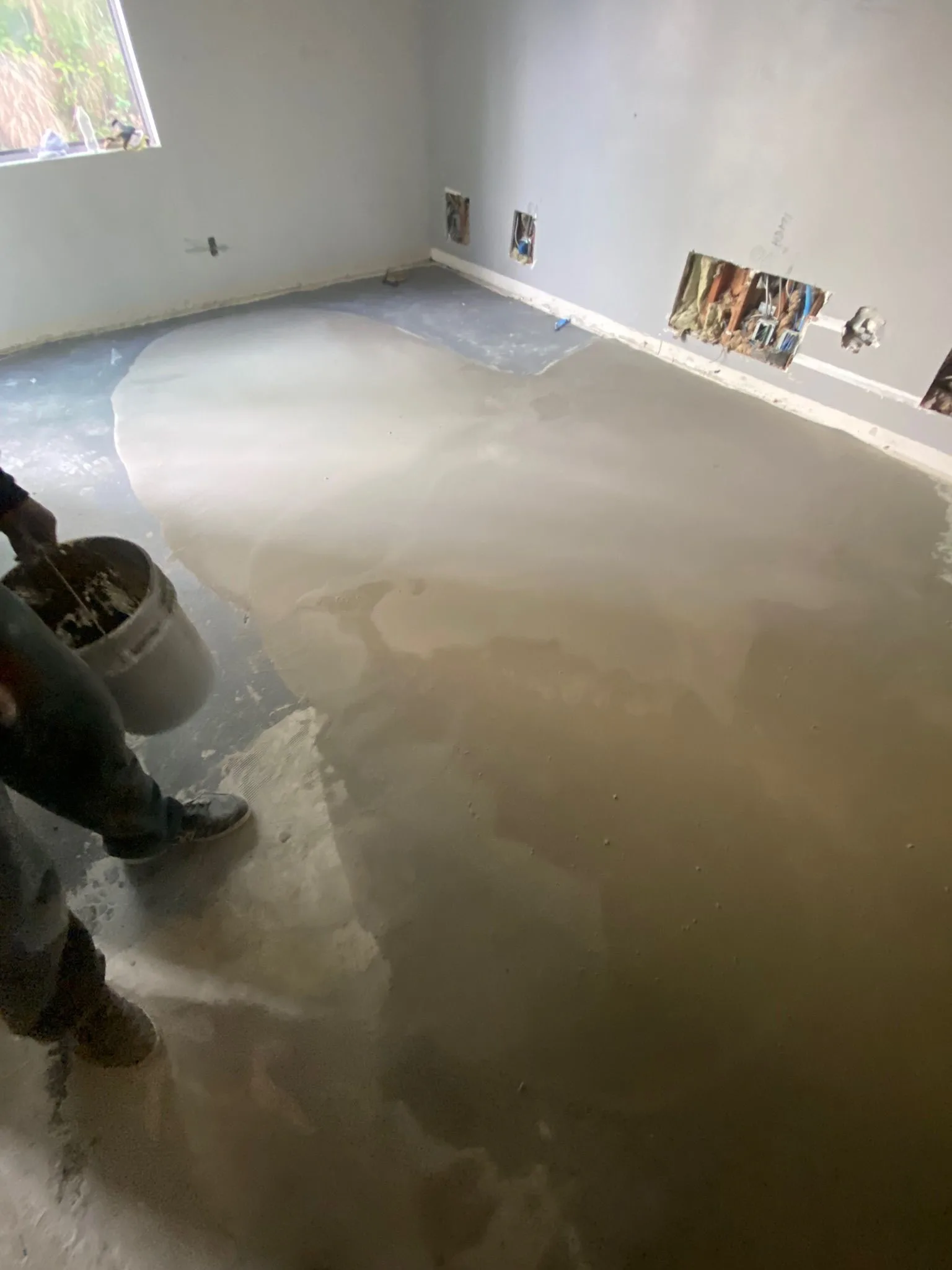 Self-leveling compound poured and spread wall to wall