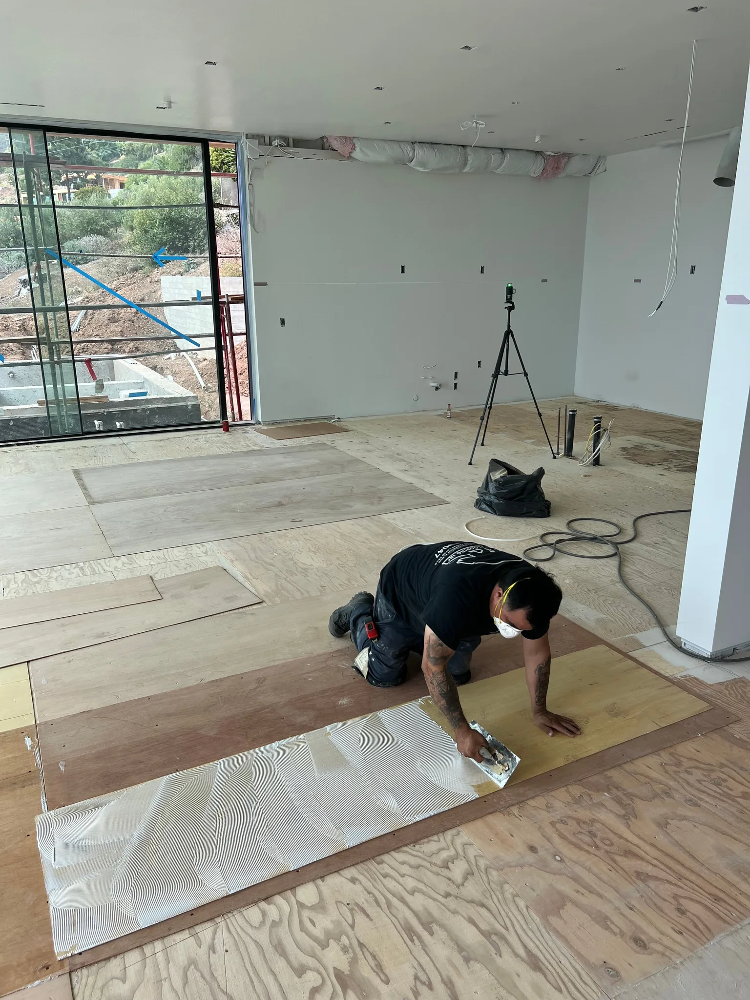 Troweling glue over subfloor. Ready for 1/8" luan