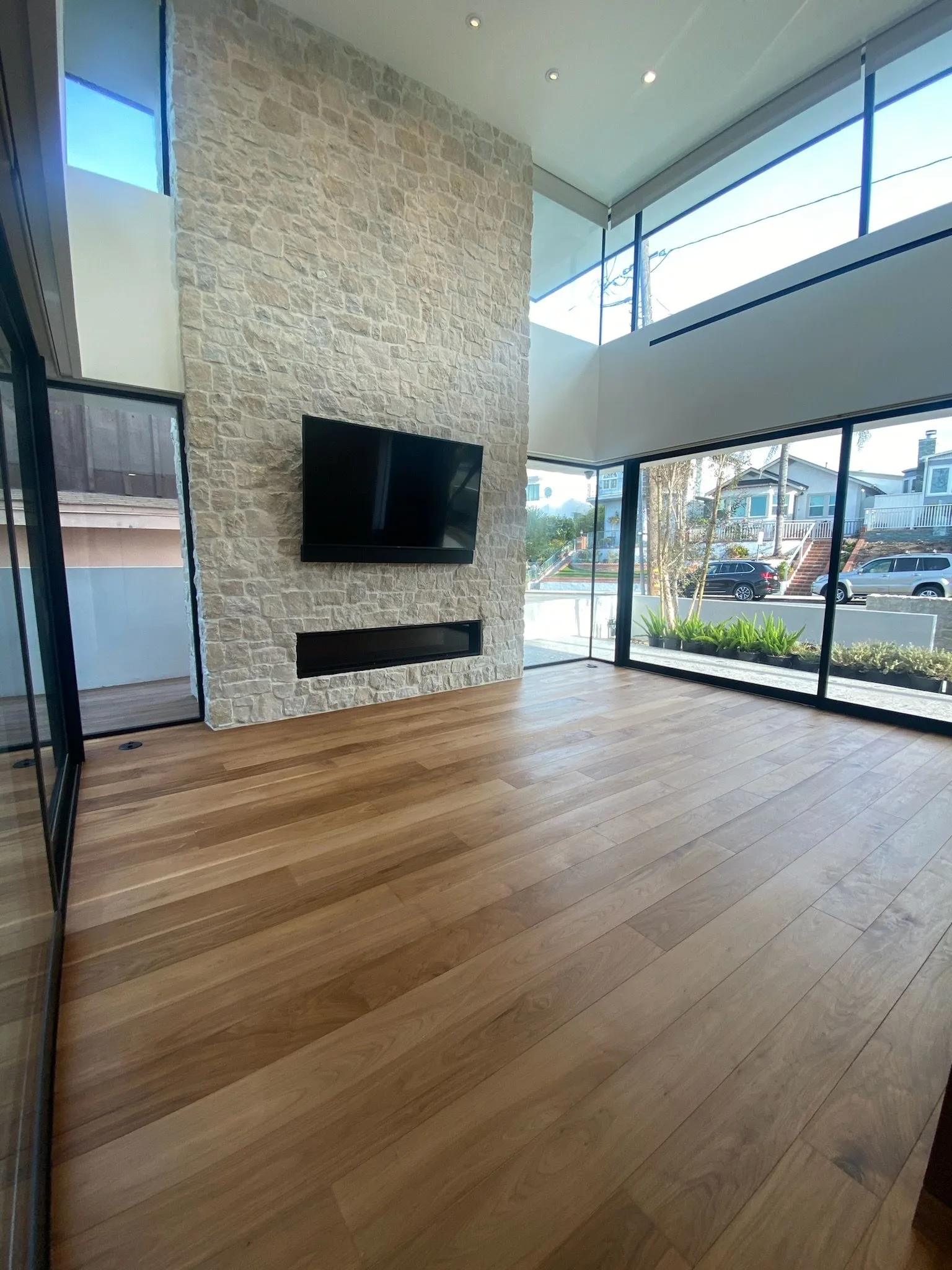 Oil-finished walnut running to a stone fireplace wall and glass doors in Hermosa Beach
