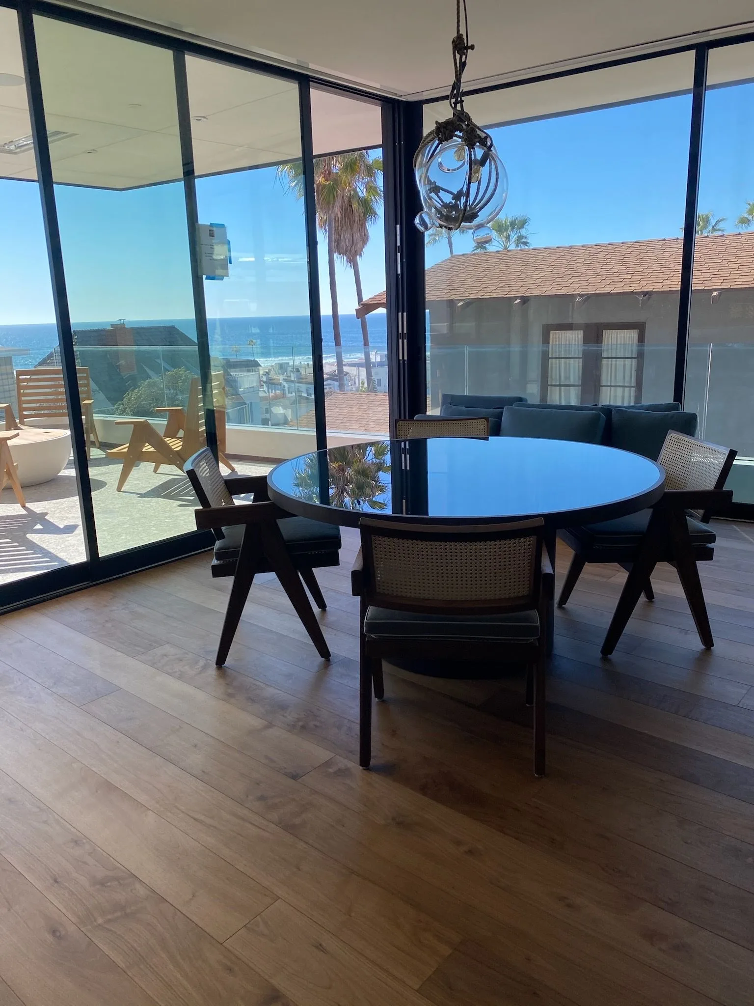 Wide-plank walnut in the dining room, windows open to the ocean in Hermosa Beach