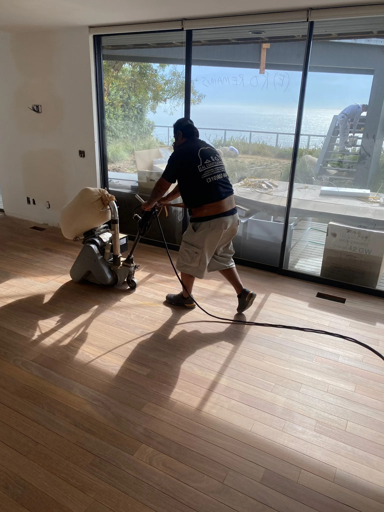 Drum sander cutting old finish off hardwood planks