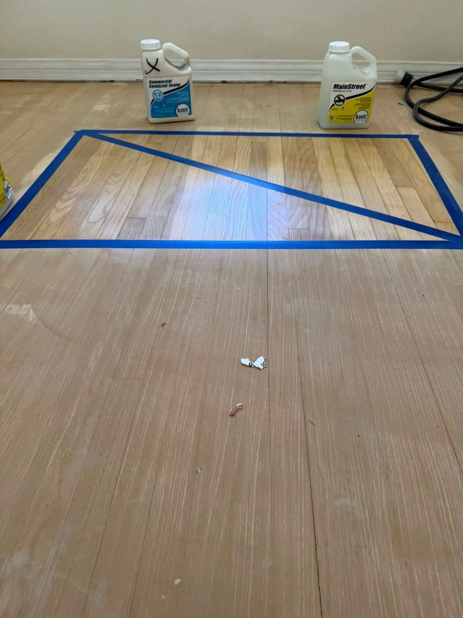 Two sealers tested side by side on raw strip flooring