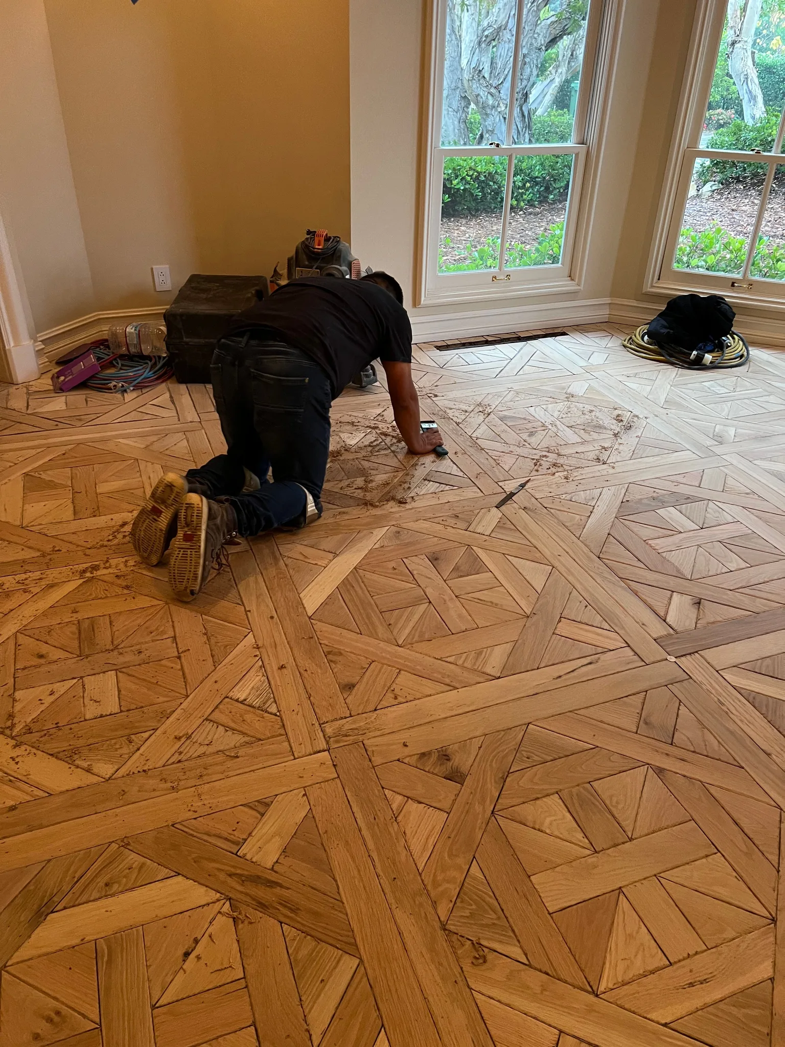 Hand tooling on a Versailles pattern parquet floor