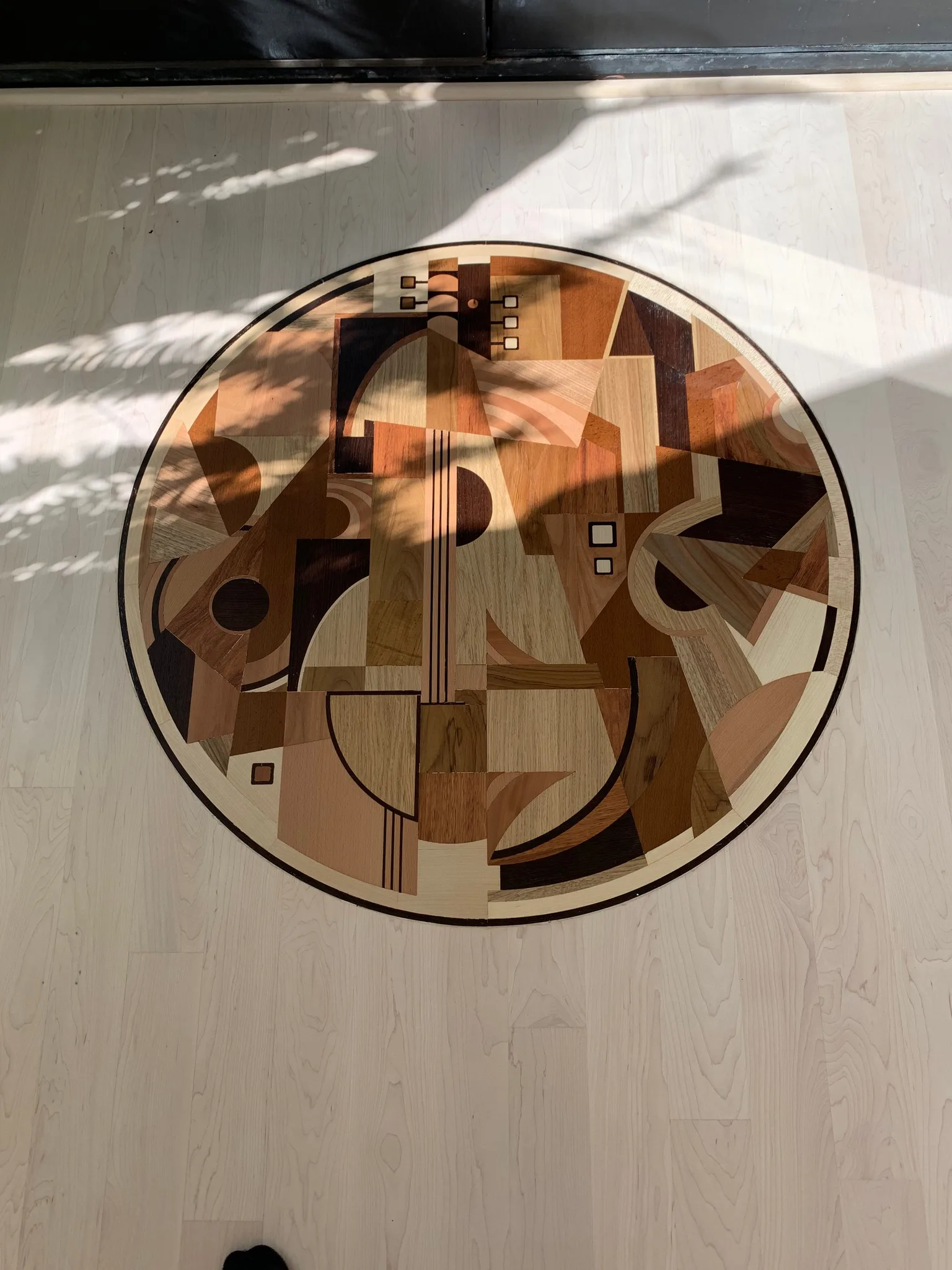 Refinished marquetry medallion inlaid in a pale strip floor