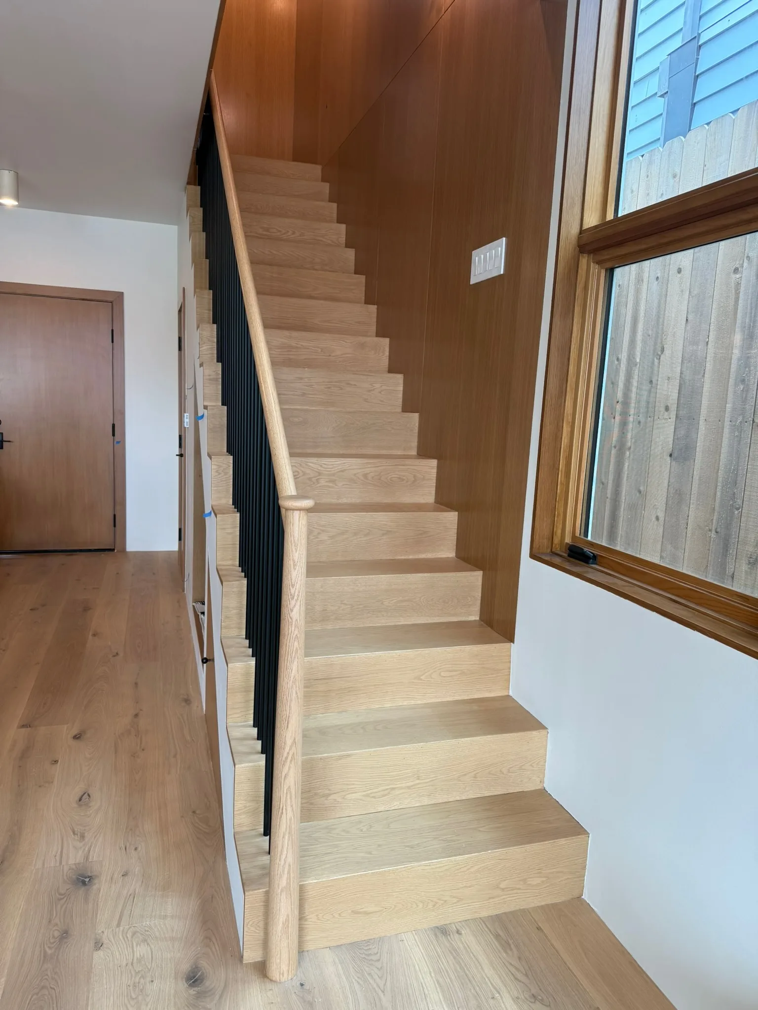 Oak stair against a wood-panelled wall