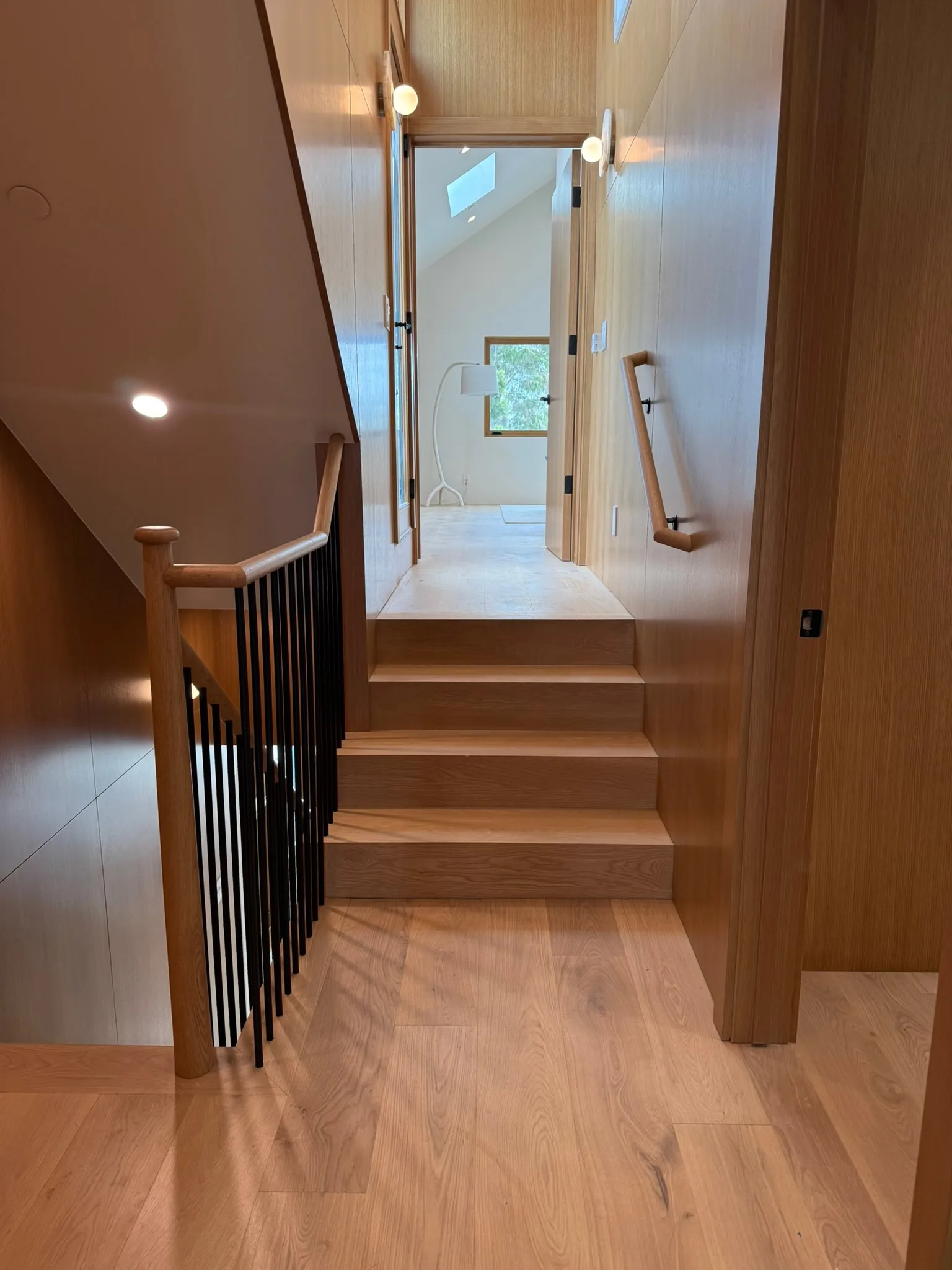 Oak steps and landing surrounded by wood wall panelling