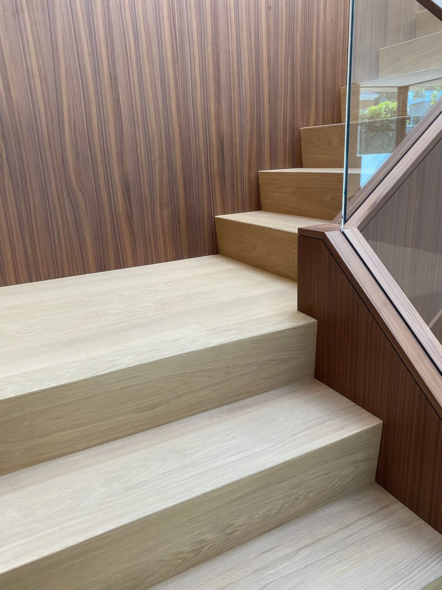 Pale oak treads against walnut panelling in Santa Monica
