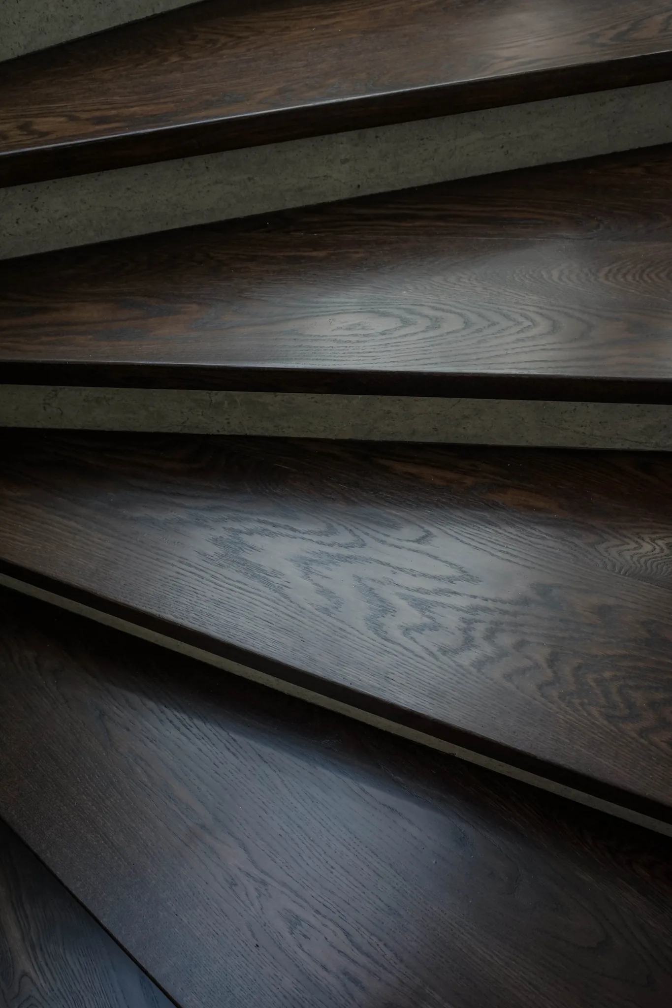 Dark brown oak treads with stone risers in Manhattan Beach