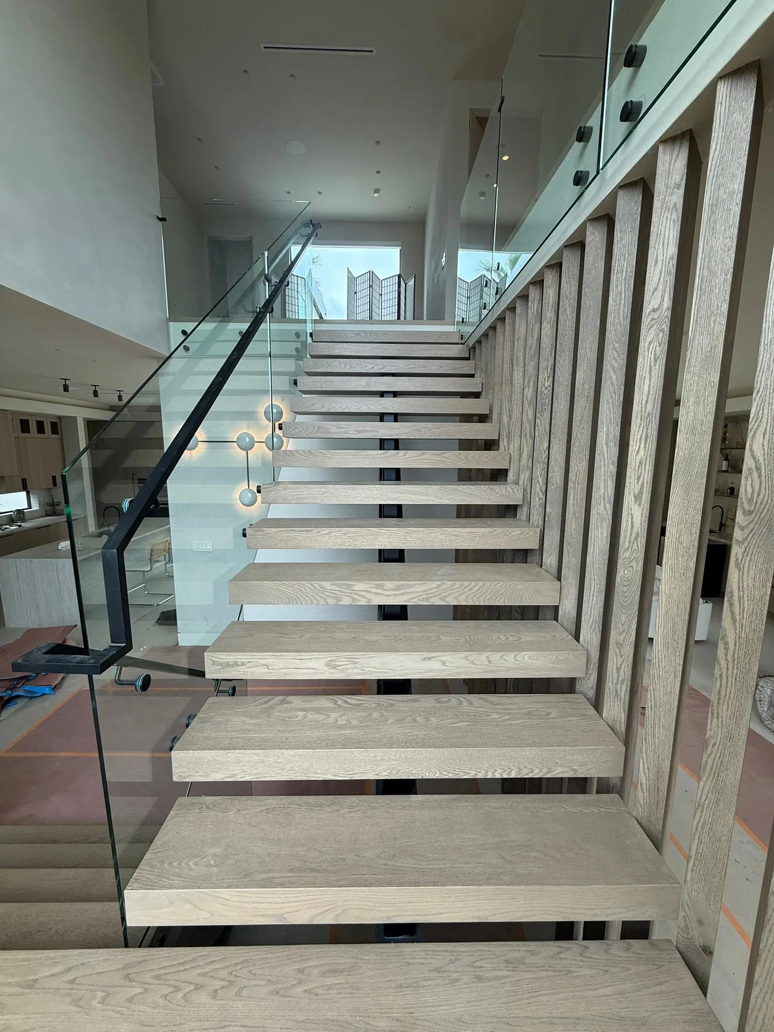 Floating oak treads beside an oak slat screen