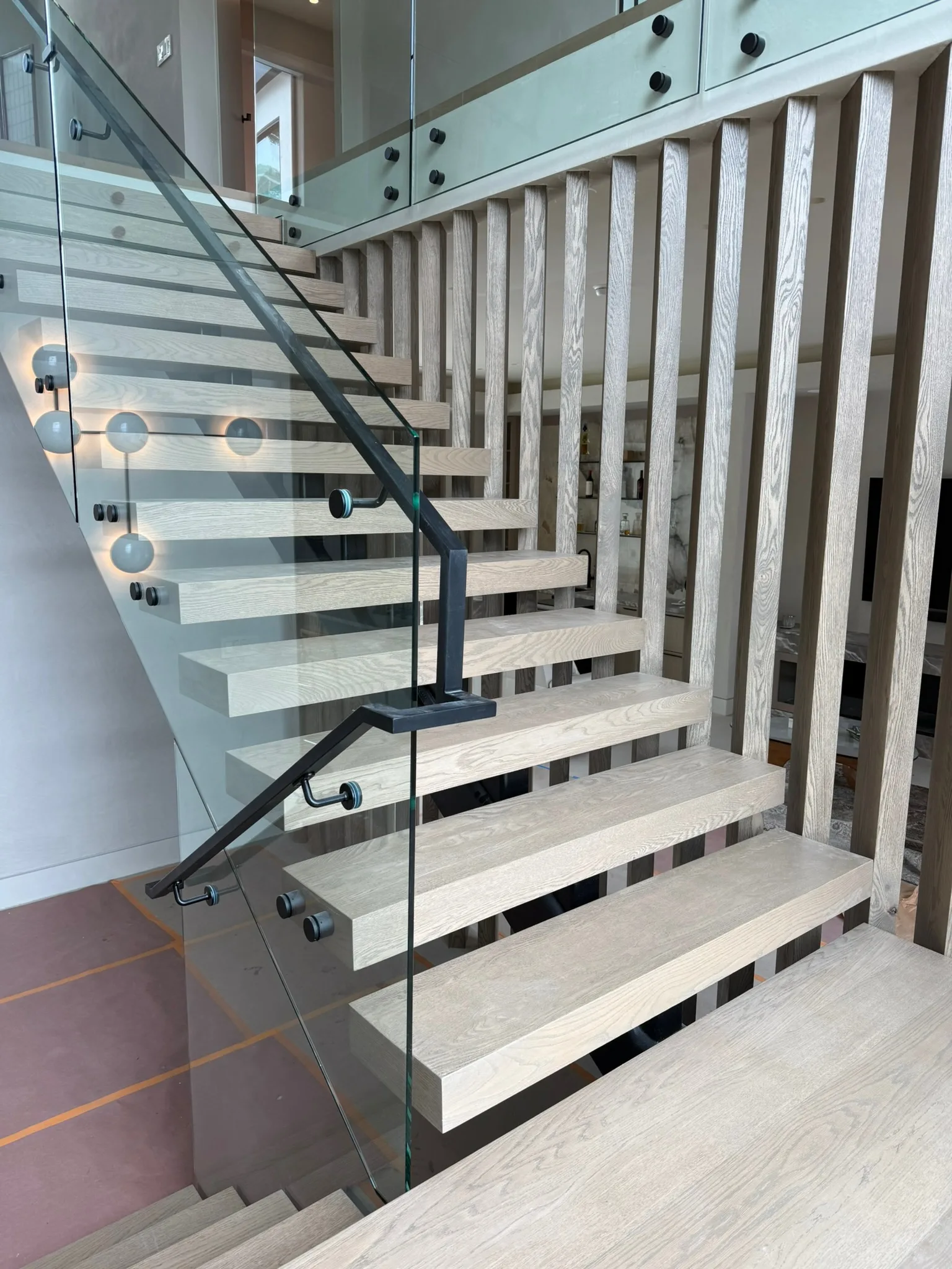 Floating oak treads behind a glass rail