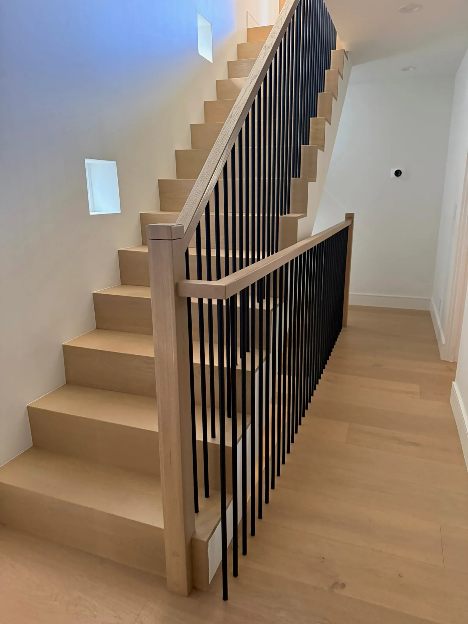 Waterfall oak treads and risers wrapped with slim black balusters