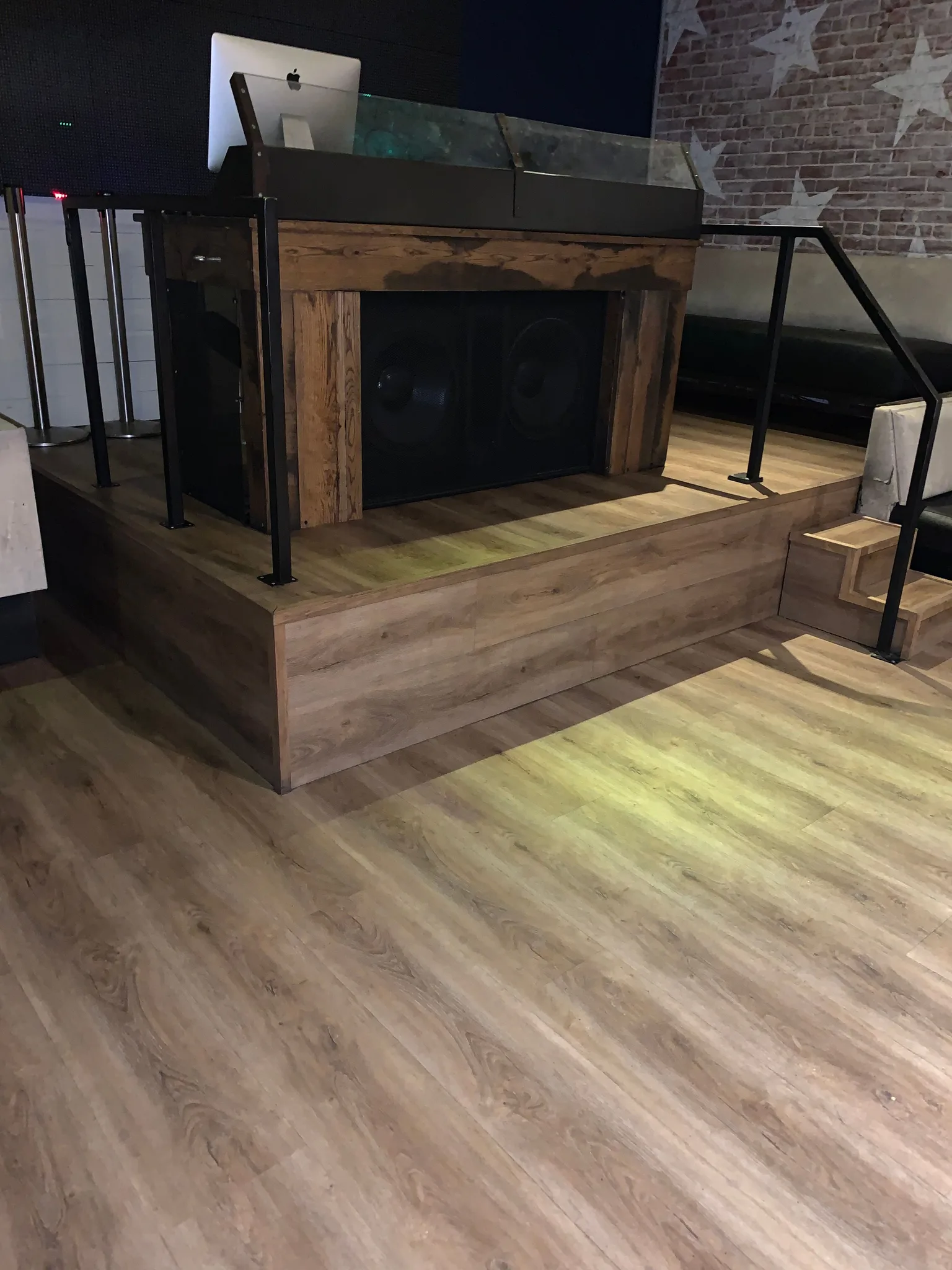 Wood-look vinyl plank wrapping a raised stage platform