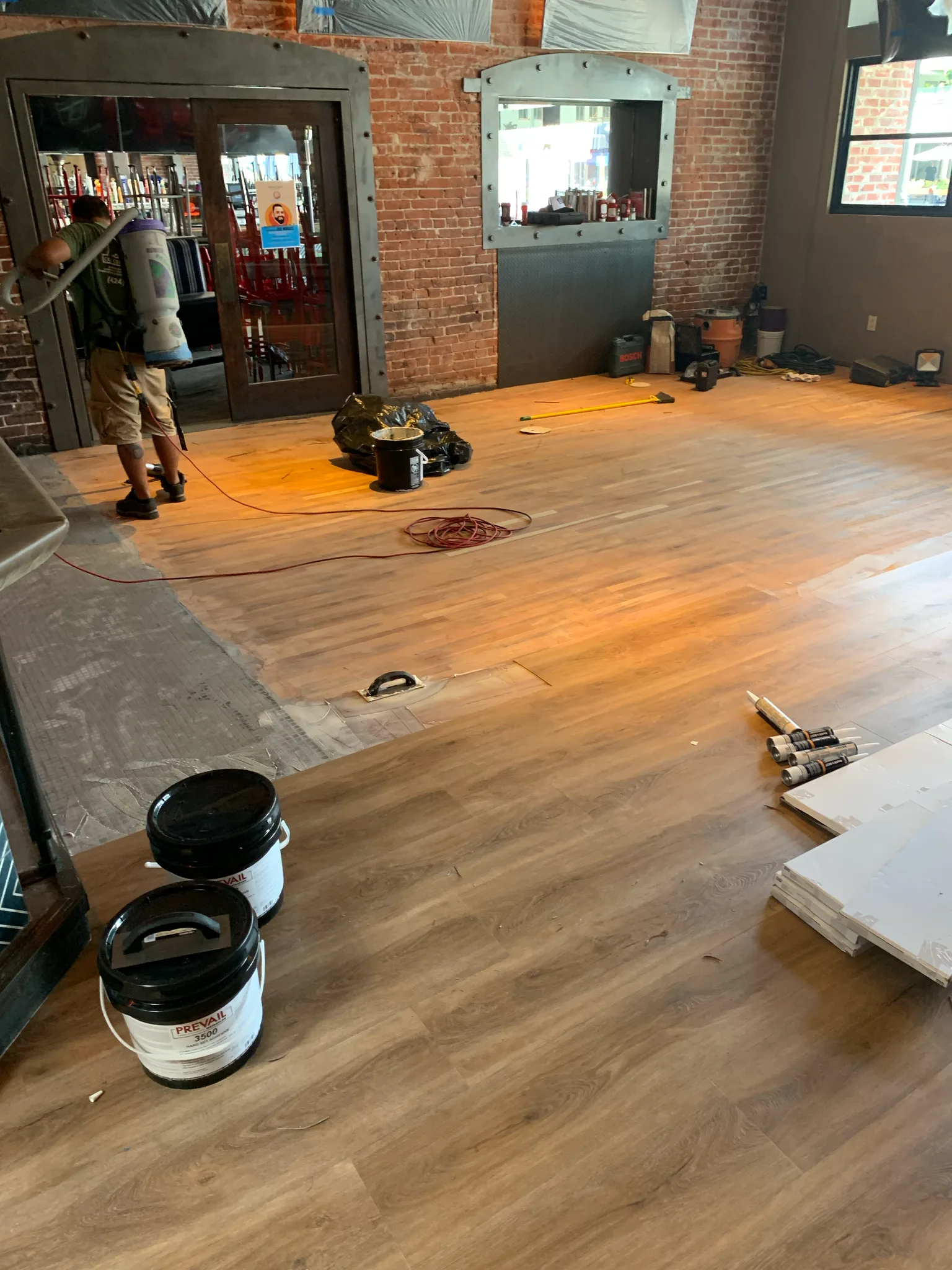 Work in progress: new luxury vinyl plank flooring going down across the American Junkie floor — Cal Coast Flooring