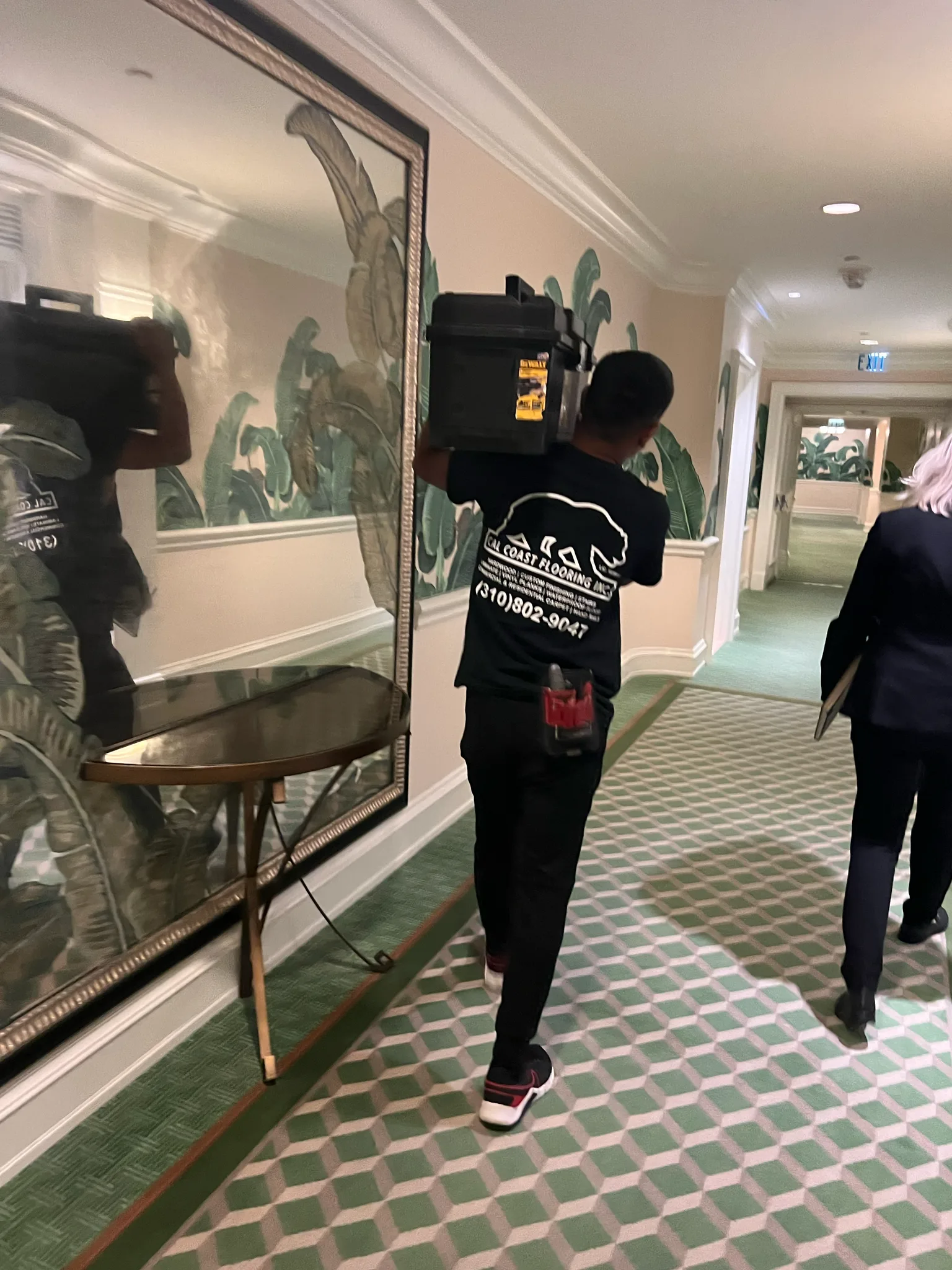 Cal Coast Flooring crew member carrying tools down a finished corridor at The Beverly Hills Hotel