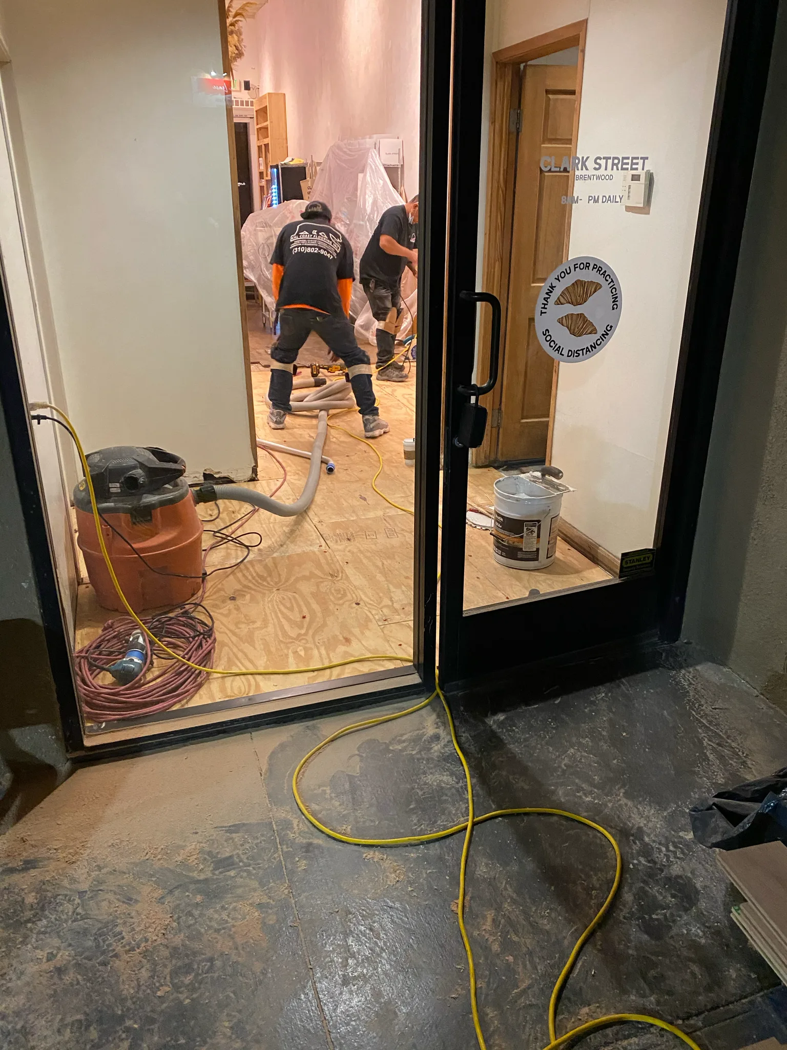 Work in progress: Cal Coast Flooring crew prepping the Clark Street Bakery floor, signage at the door