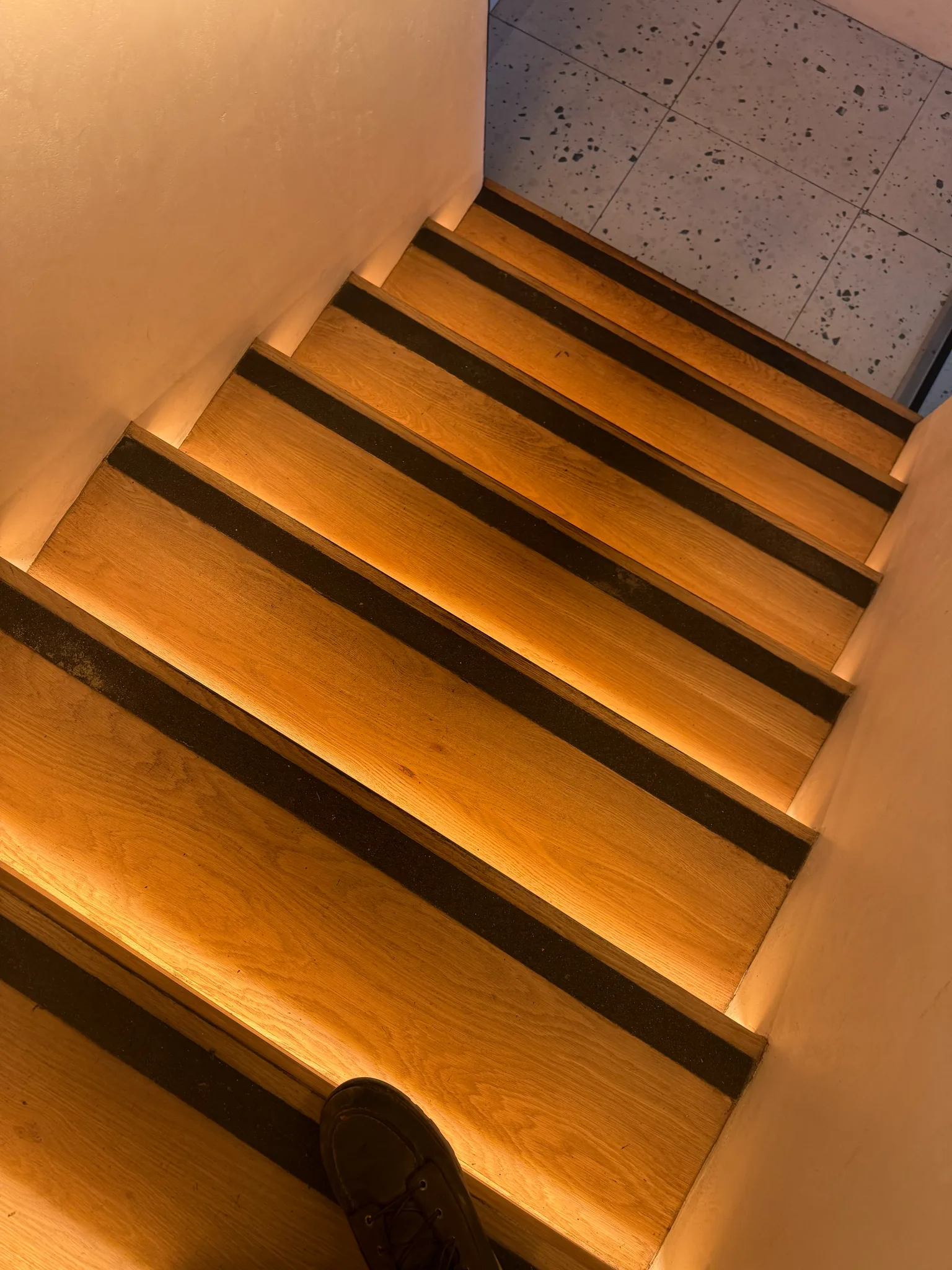 Wood stair treads with dark inlays and LED underlighting installed by Cal Coast Flooring at Esperanza