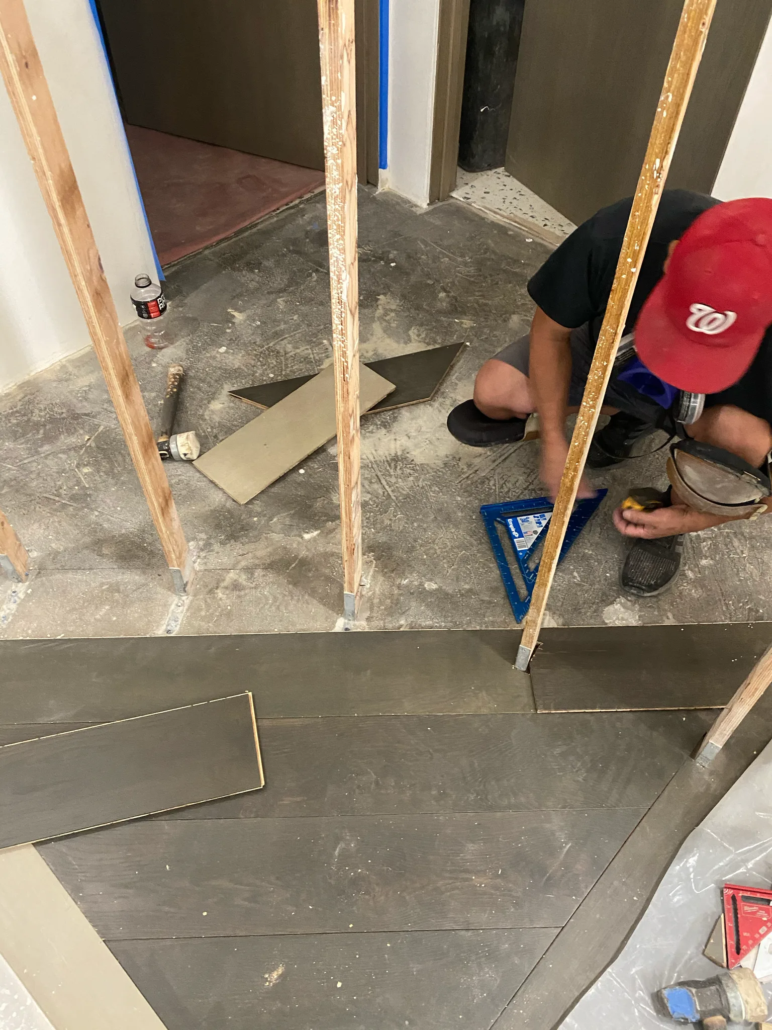 Work in progress: Cal Coast Flooring installer cutting dark planks during the Esperanza build-out