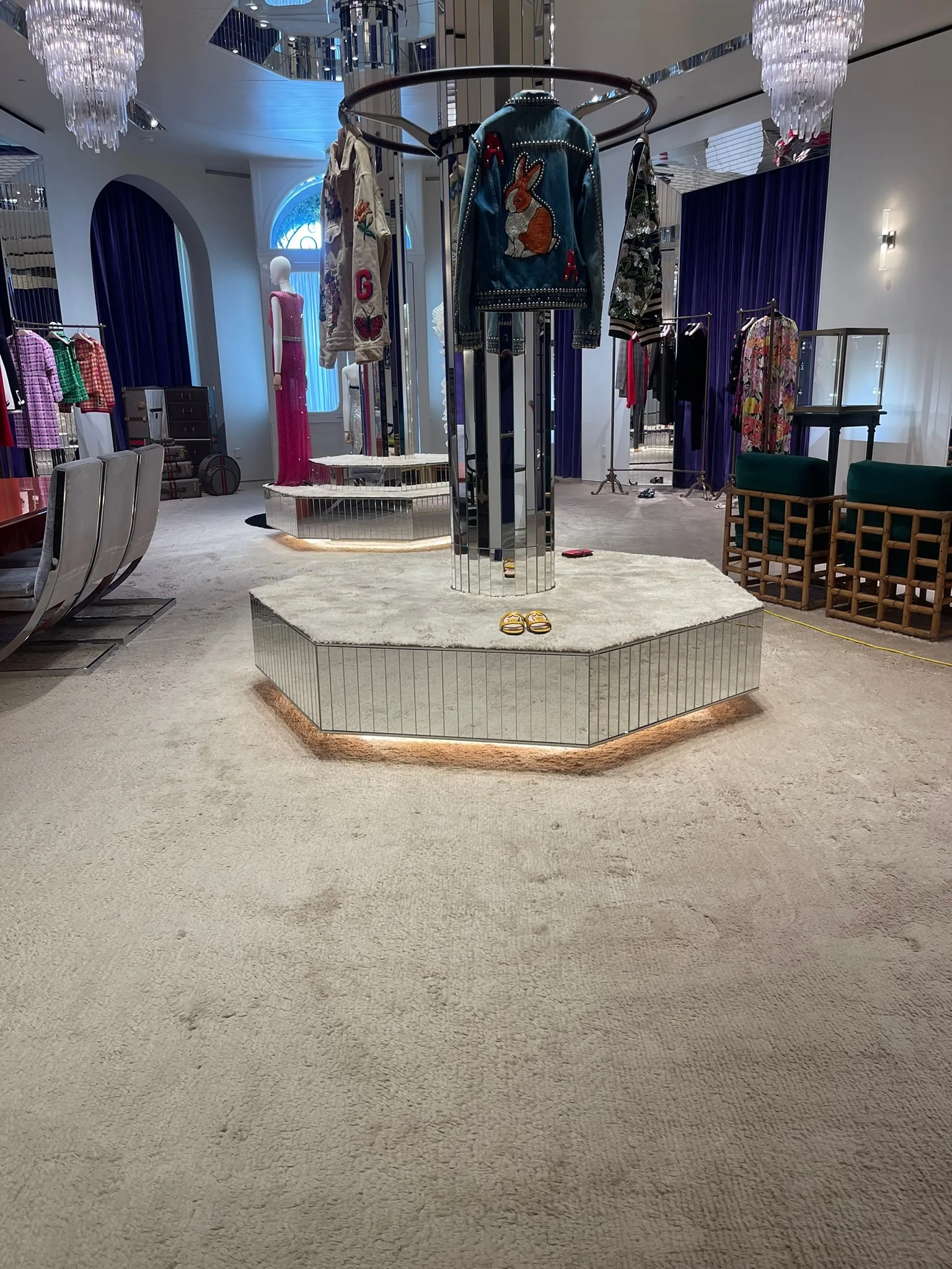 Wall-to-wall plush carpet around mirrored display plinths at Gucci Melrose Place