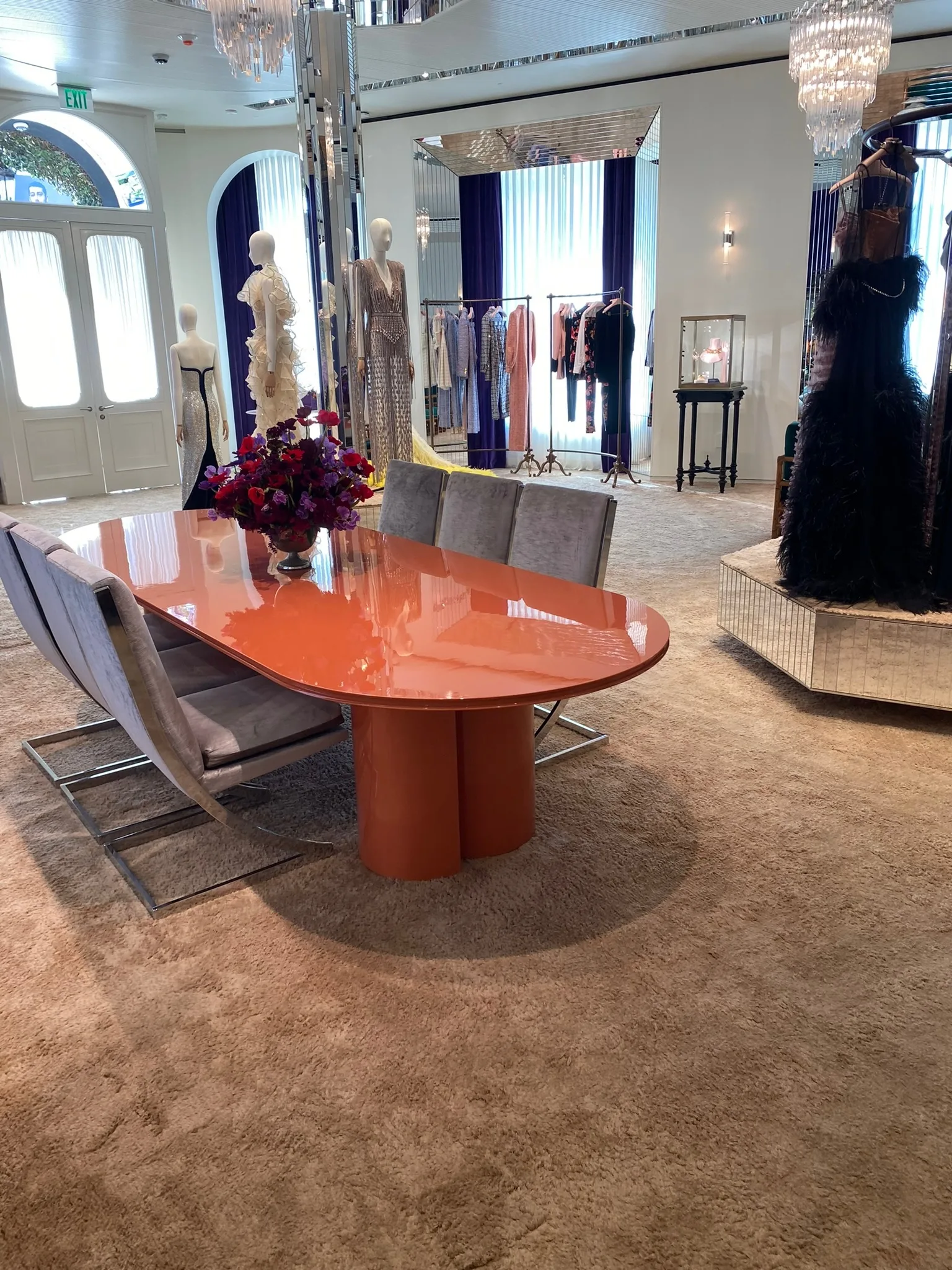 Custom cream carpet beneath the lacquered table and gown displays at Gucci Melrose Place