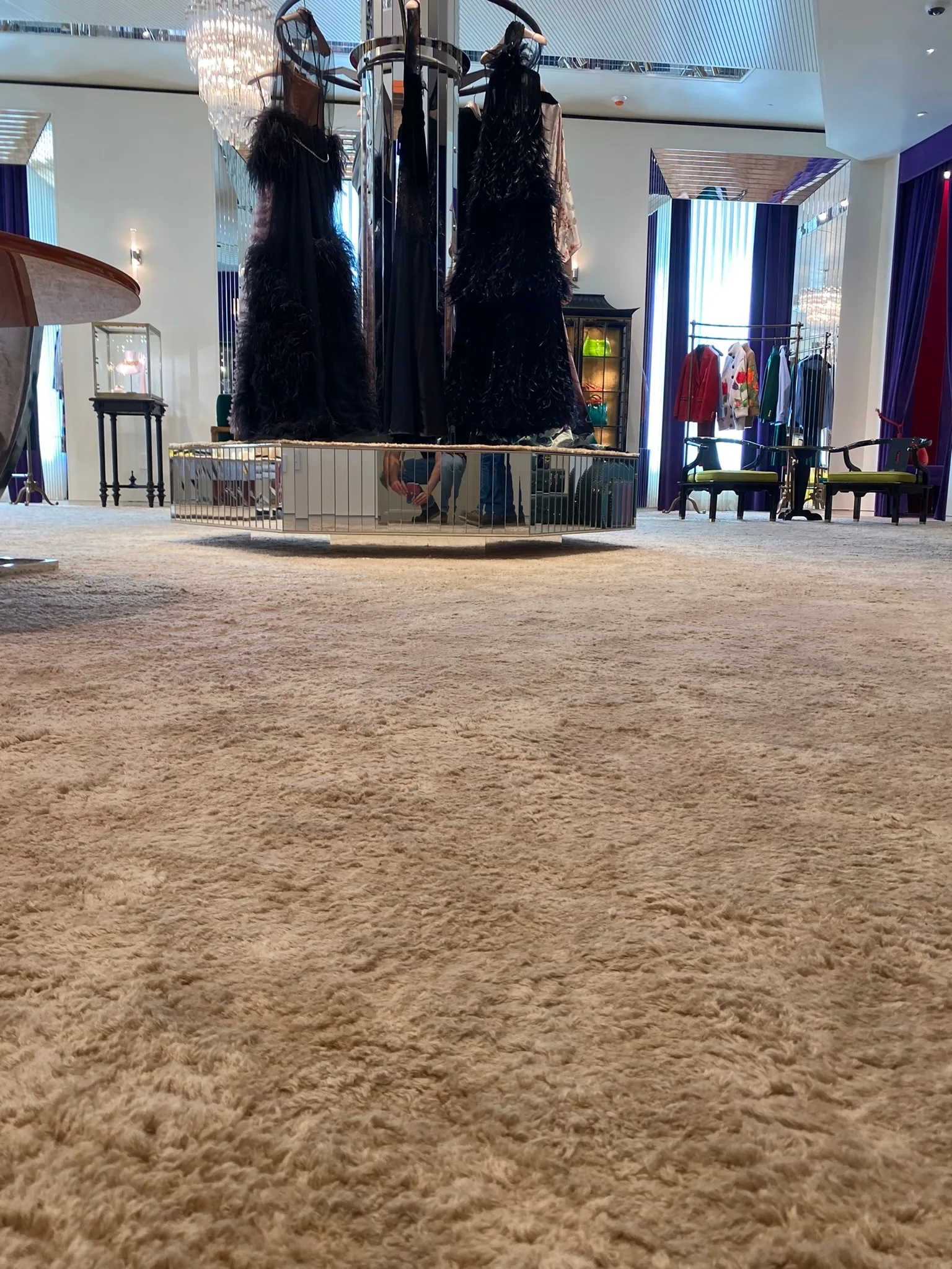 Deep-pile carpet detail on the Gucci Melrose Place salon floor, evening gowns beyond