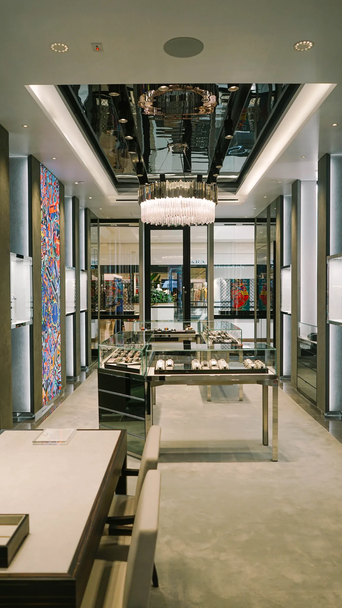 Wall-to-wall grey carpet under the watch display cases and chandelier in a Hublot boutique