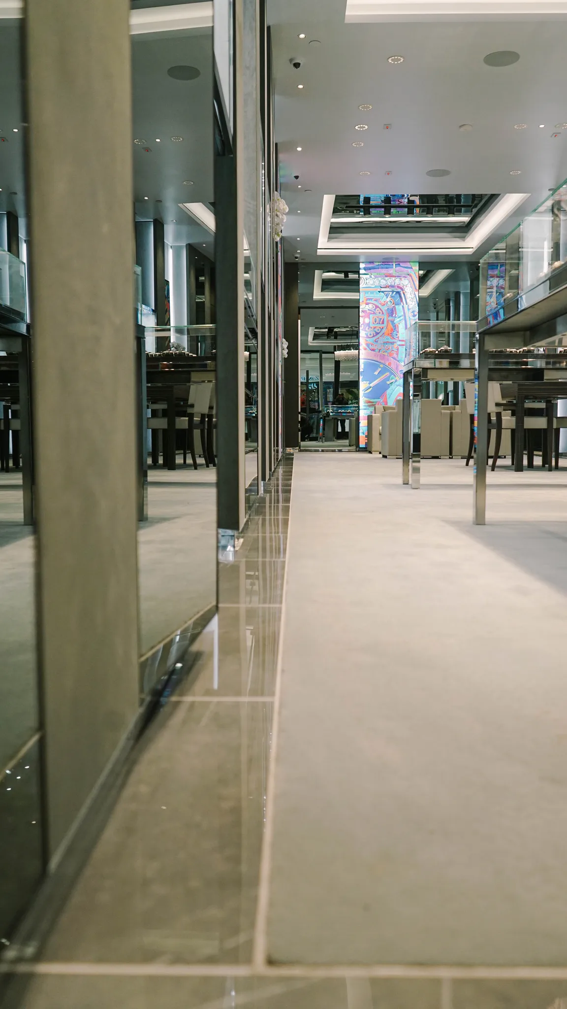 Carpet edge meeting the polished stone border at the base of a mirrored wall in a Hublot boutique