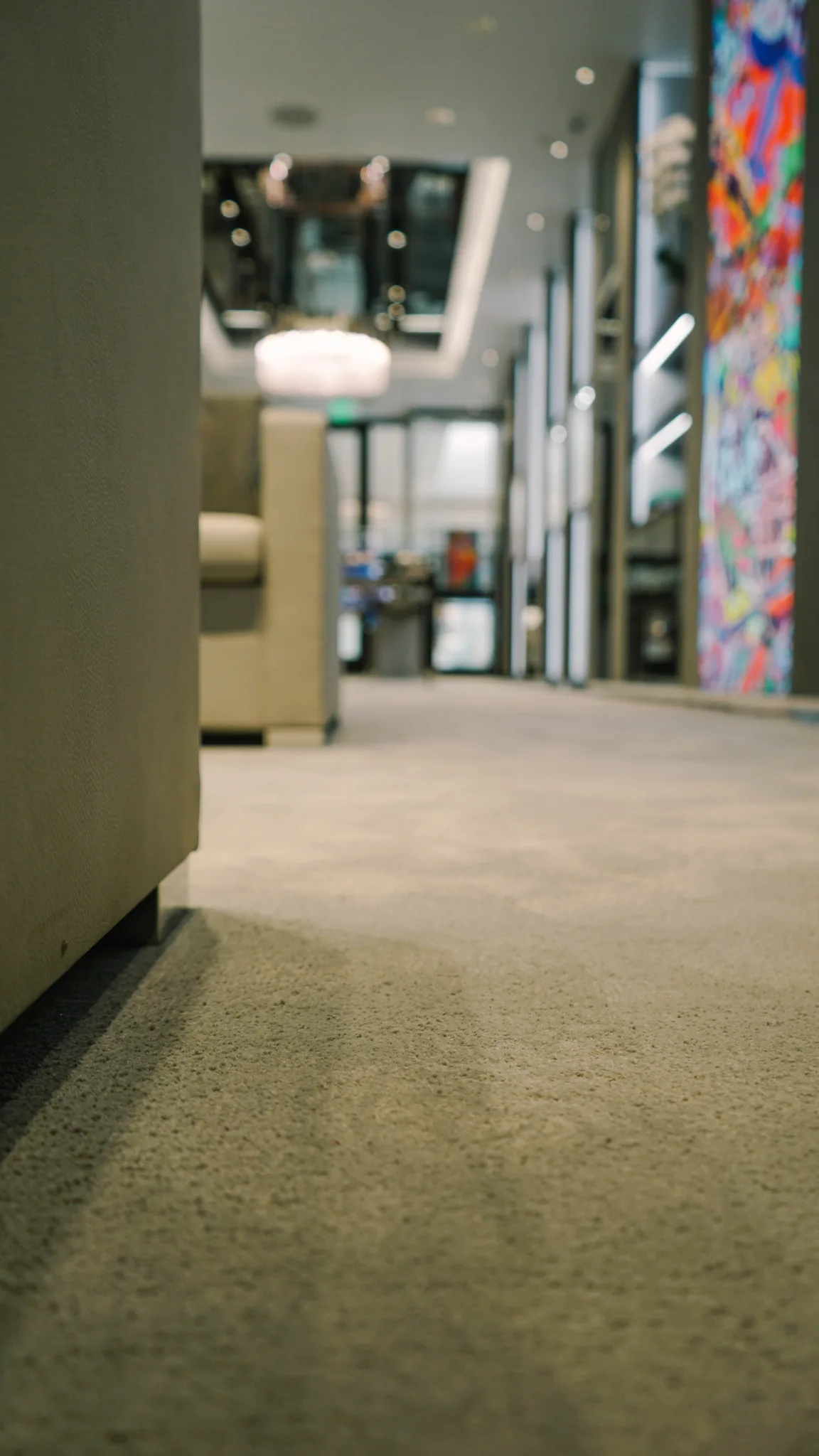 Close view of the plush grey carpet pile in a Hublot boutique, art panel beyond
