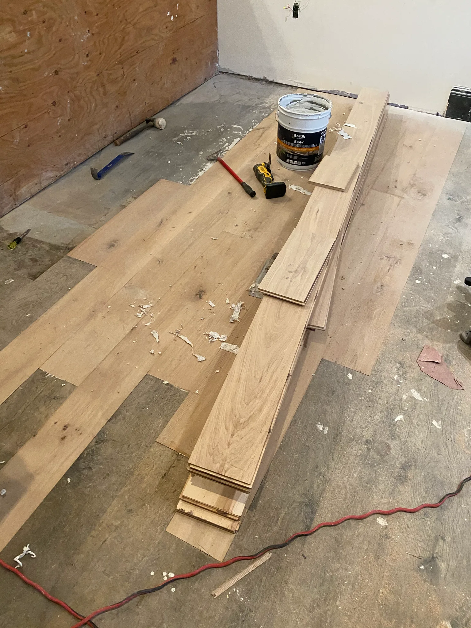 Custom-milled hardwood planks being fitted into the existing floor at Nando Trattoria