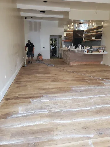 Cal Coast Flooring sanding the entire dining room floor at Nando Trattoria before staining