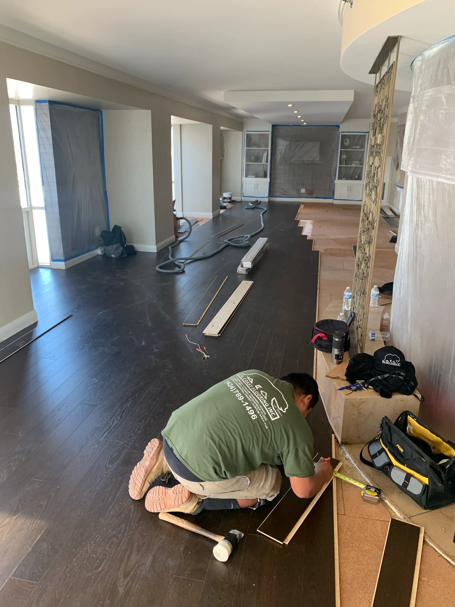 Work in progress: Cal Coast Flooring installer fitting dark hardwood planks in a suite at Omni Los Angeles
