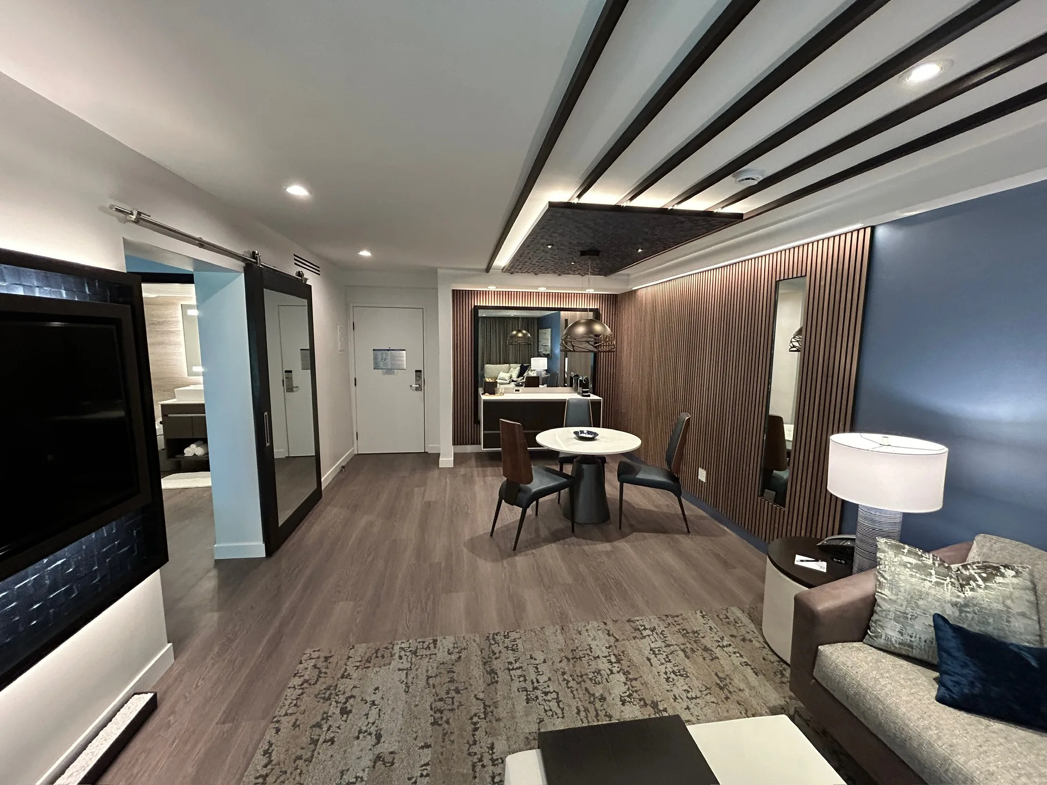Wood-look plank flooring through a Sunset Marquis suite, looking past the dining table toward the entry