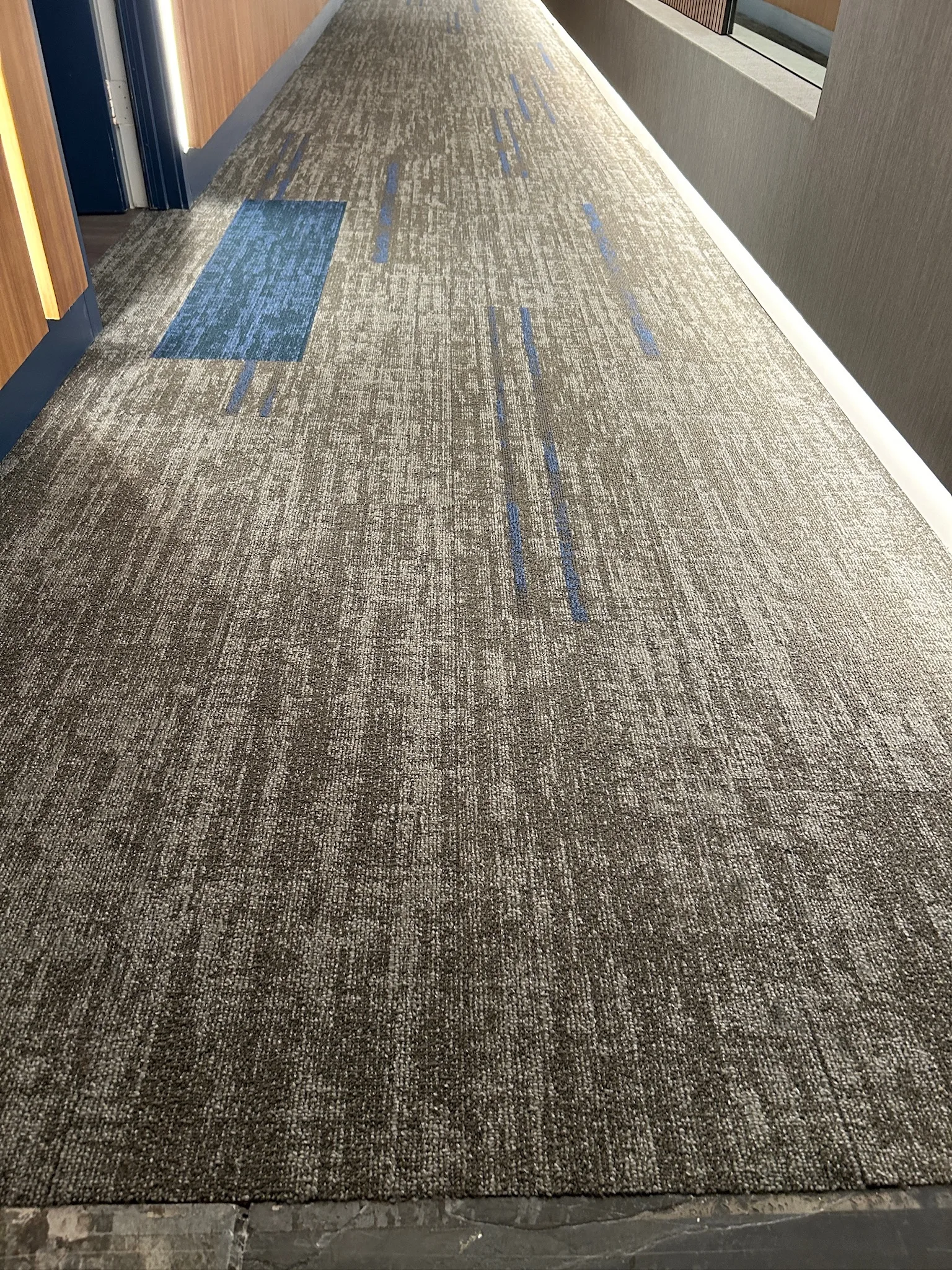 Close view of the textured gray-and-blue carpet tile in a Sunset Marquis corridor