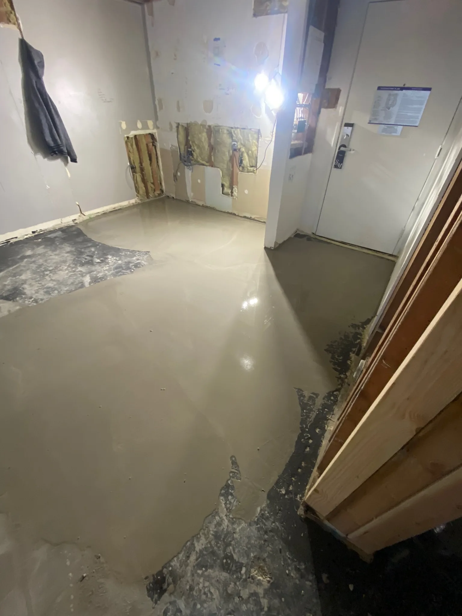 Freshly poured floor-leveling compound across a gutted guest room at the Sunset Marquis before the new floor